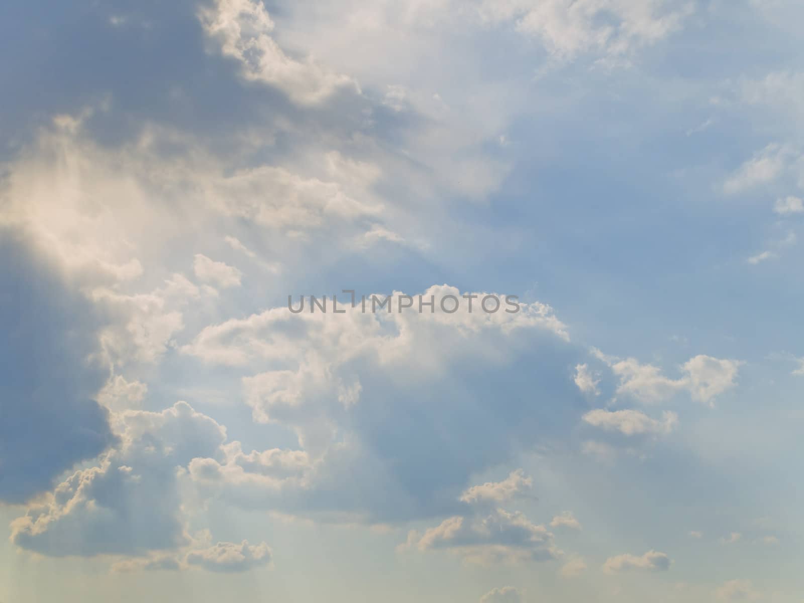 Clouds at the blue sky with sun shaft