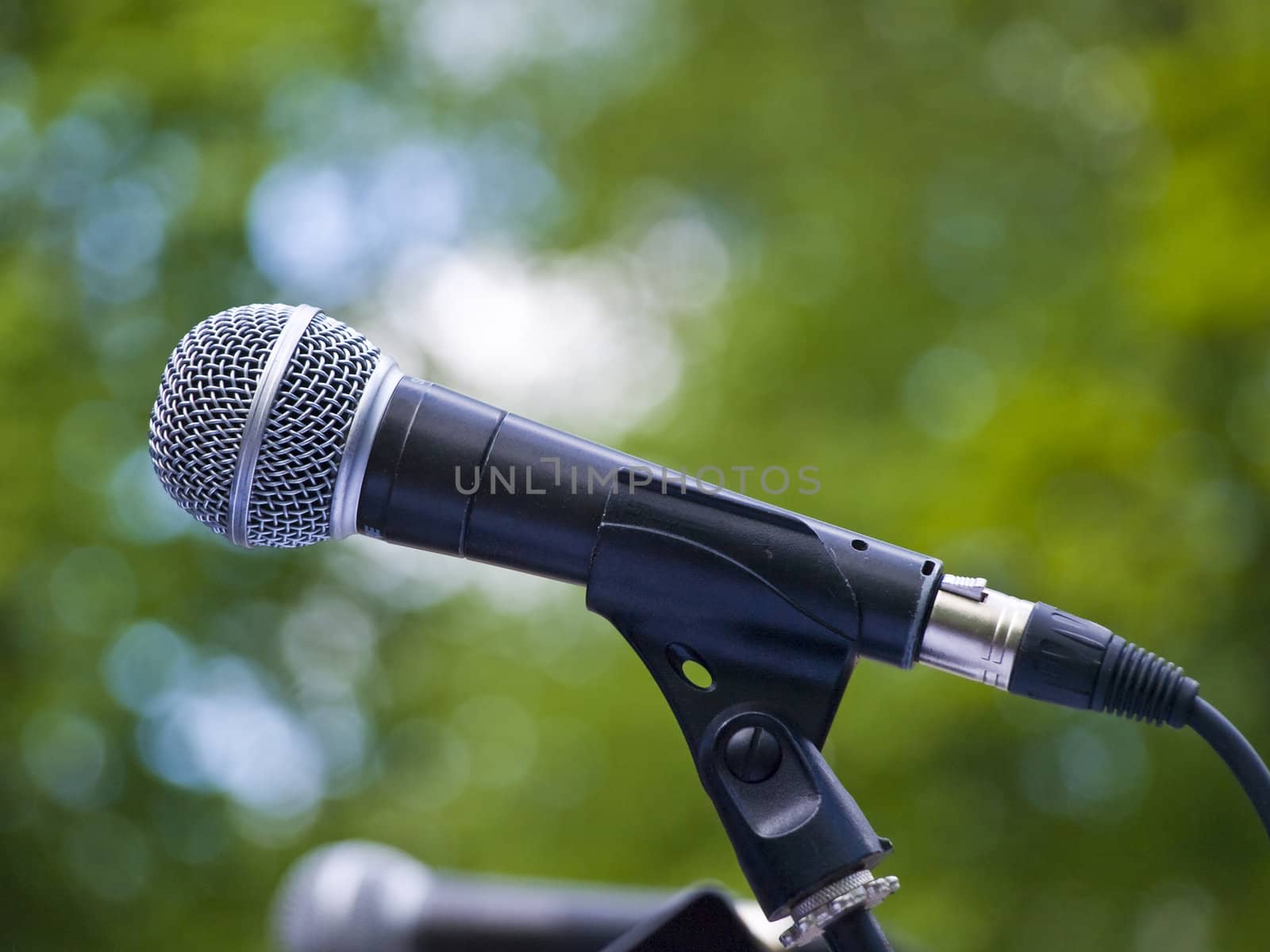 Single microphone against the green leaves background