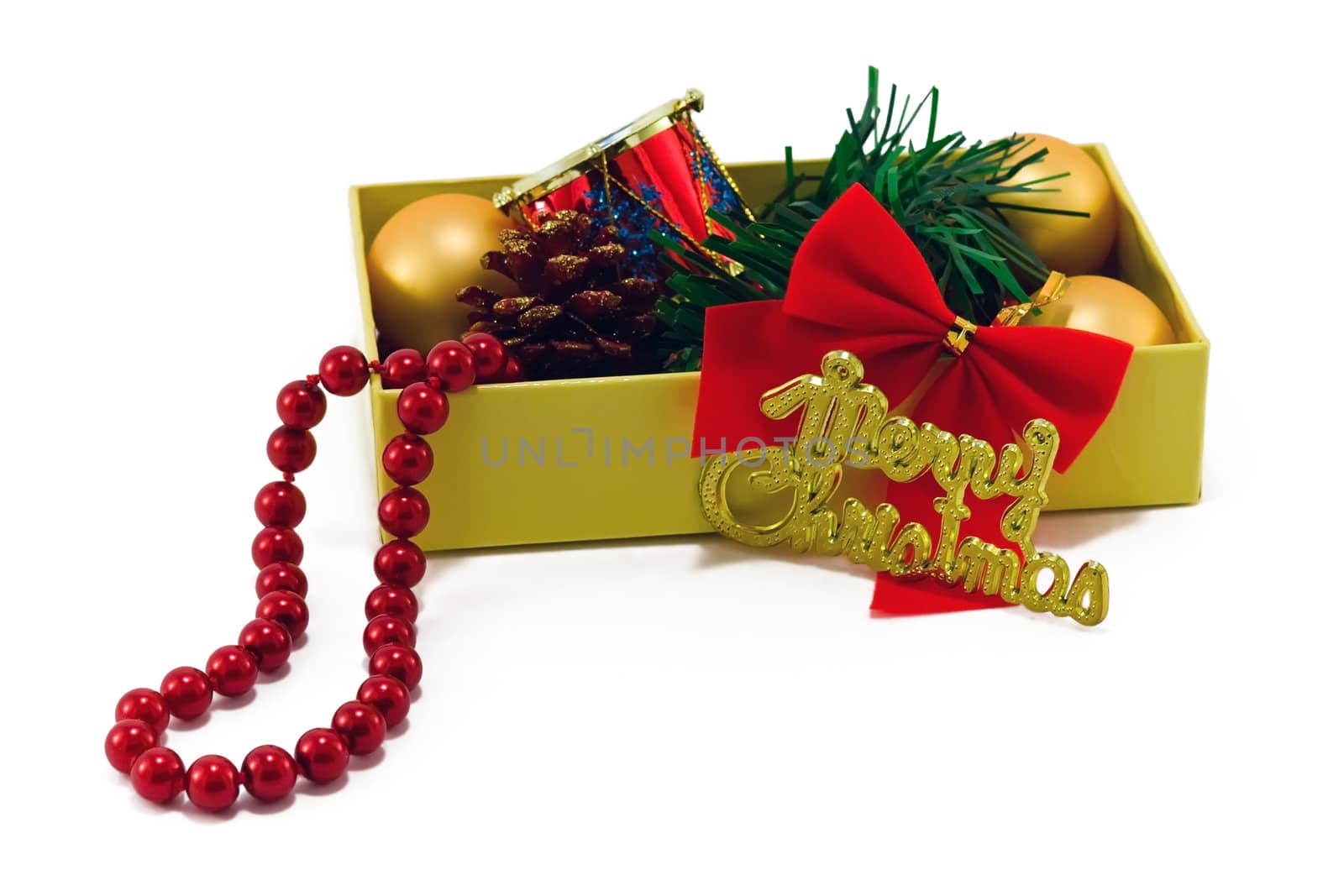 Christmas box with golden balls, strobile, beads and red drum on white