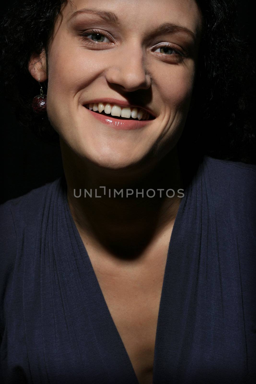 Young happy laughing woman over black background