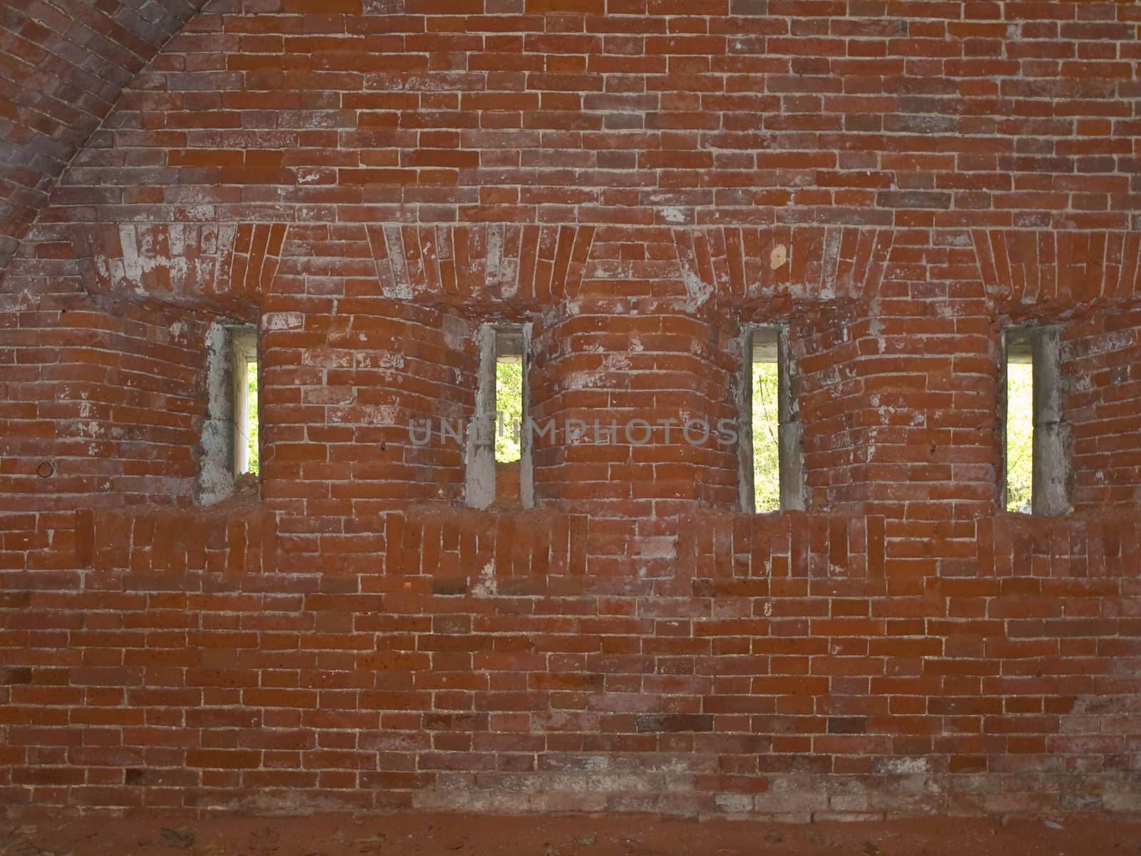 row of narrow loopholes in the red brick wall