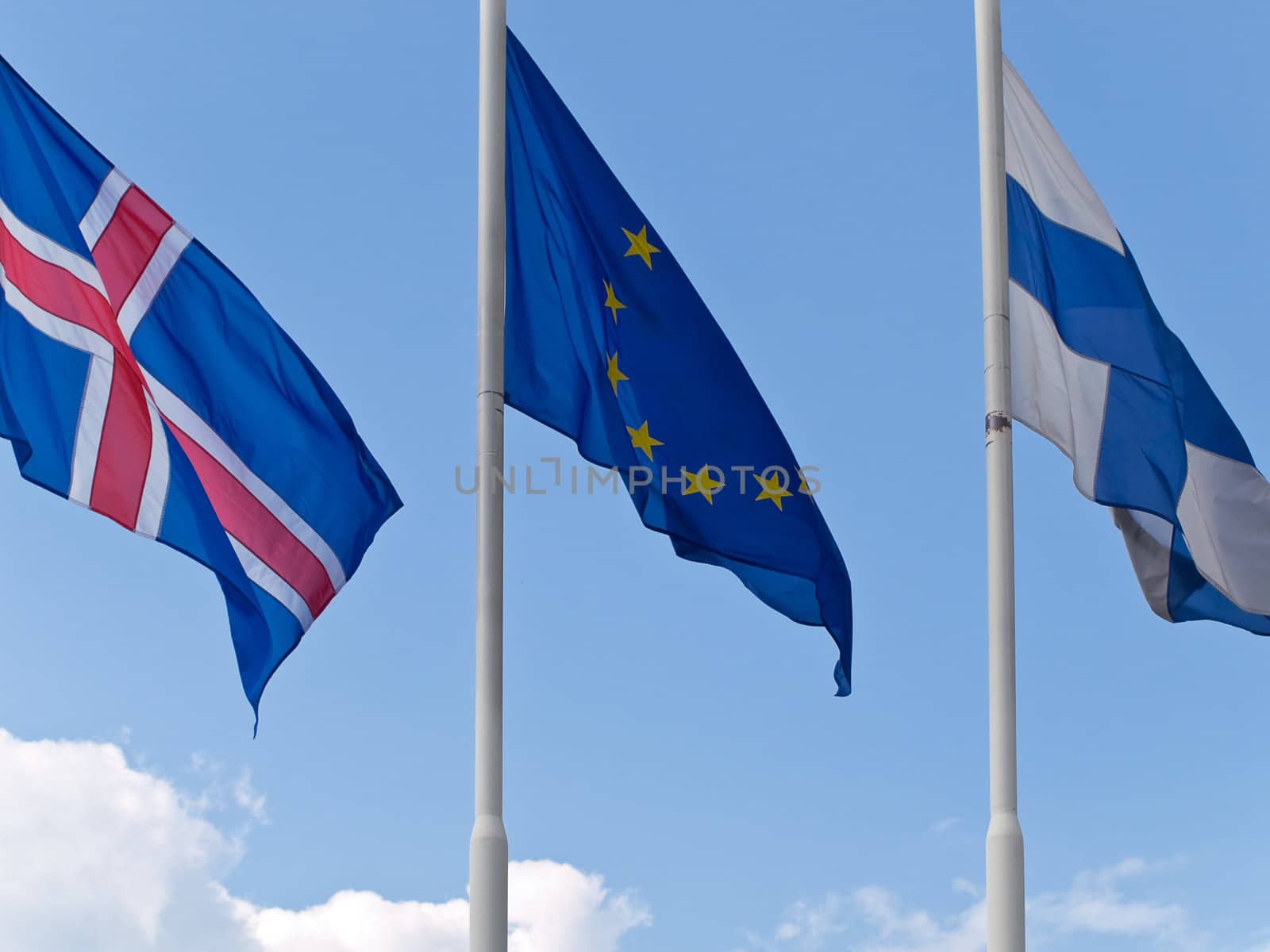 three different flags against the blue sky