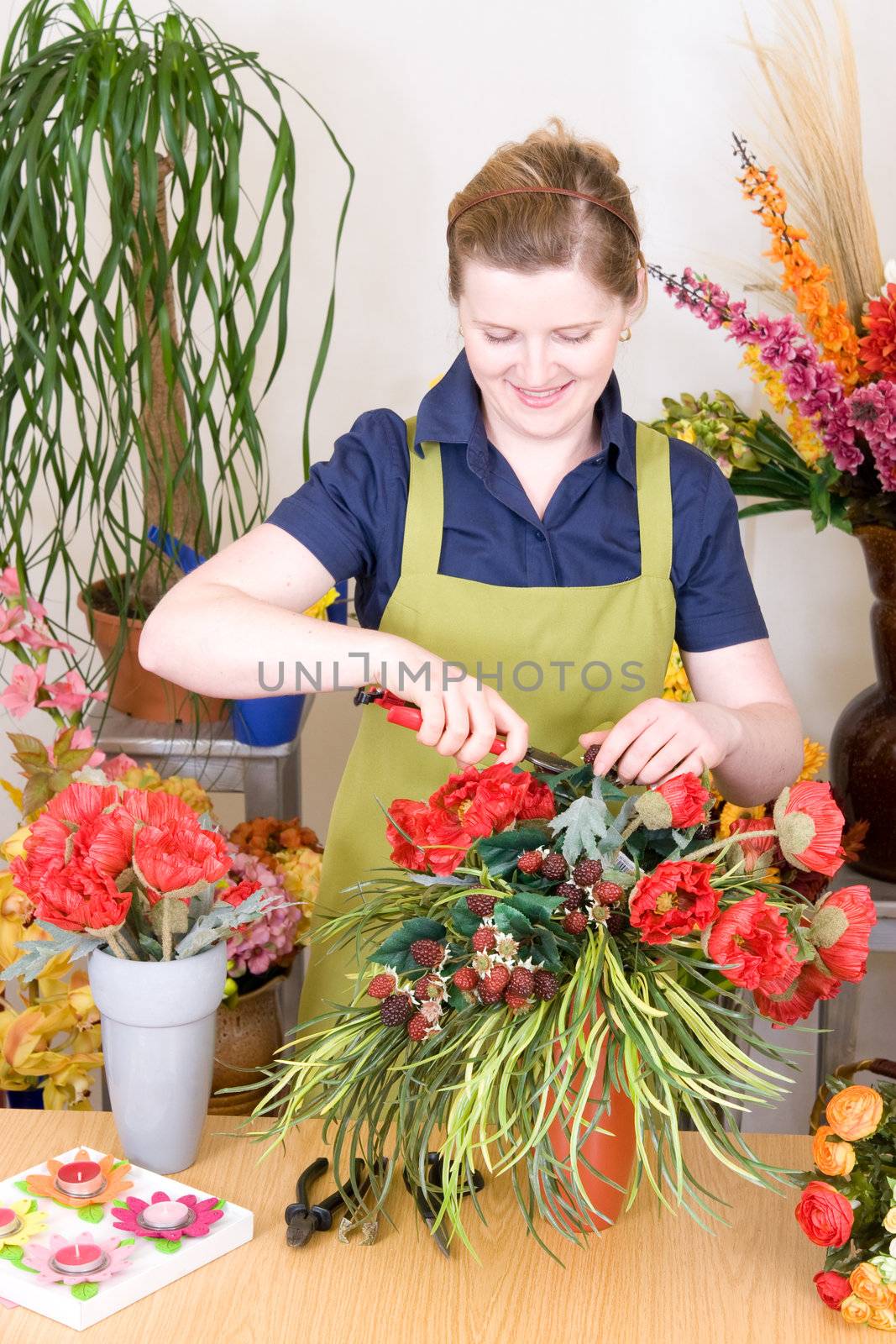 Young florist cutting flowers and working on an arrangement