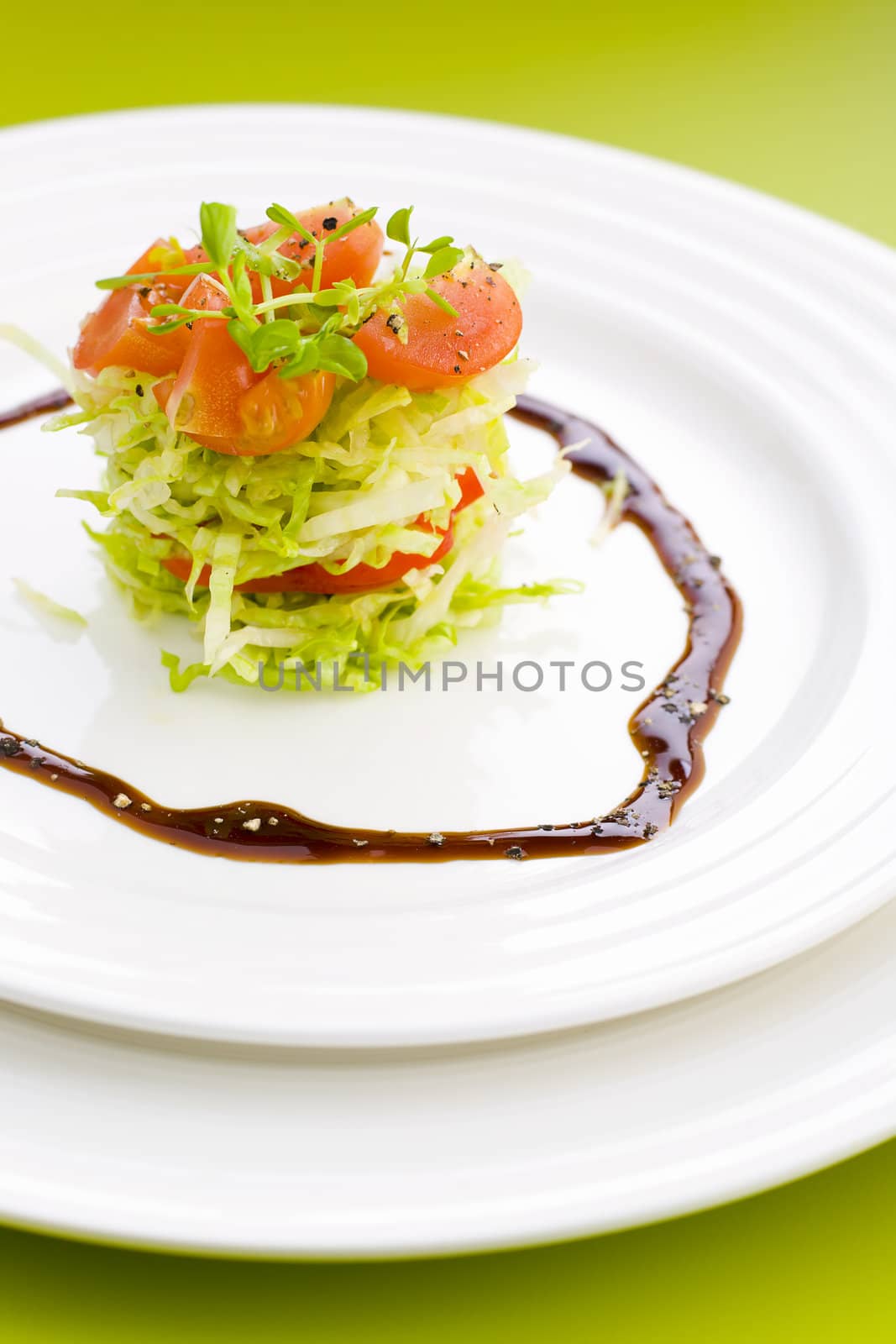 Salad on the plate with black pepper and vinegard syrap