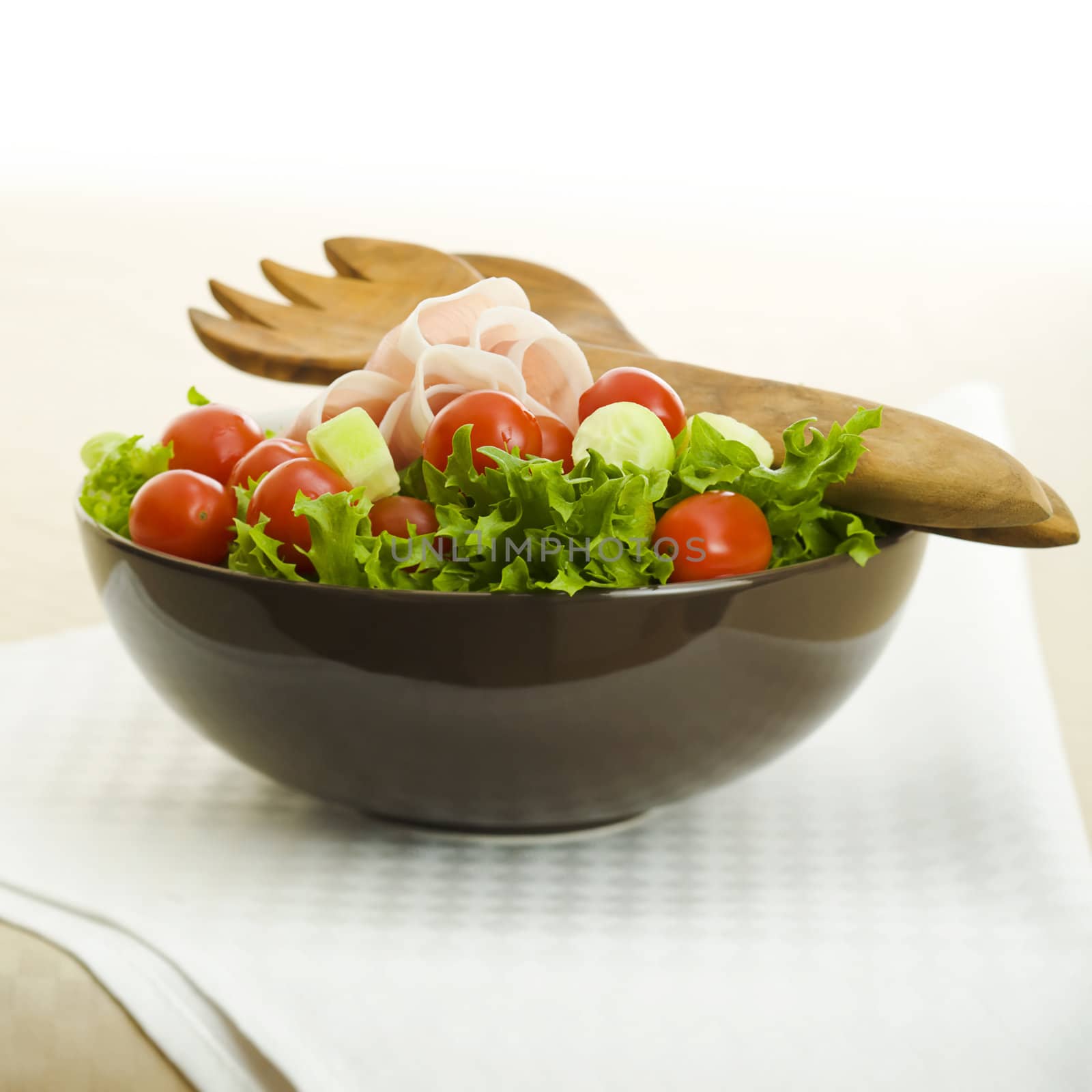 Prosciutto salad with wooden spoon on the table