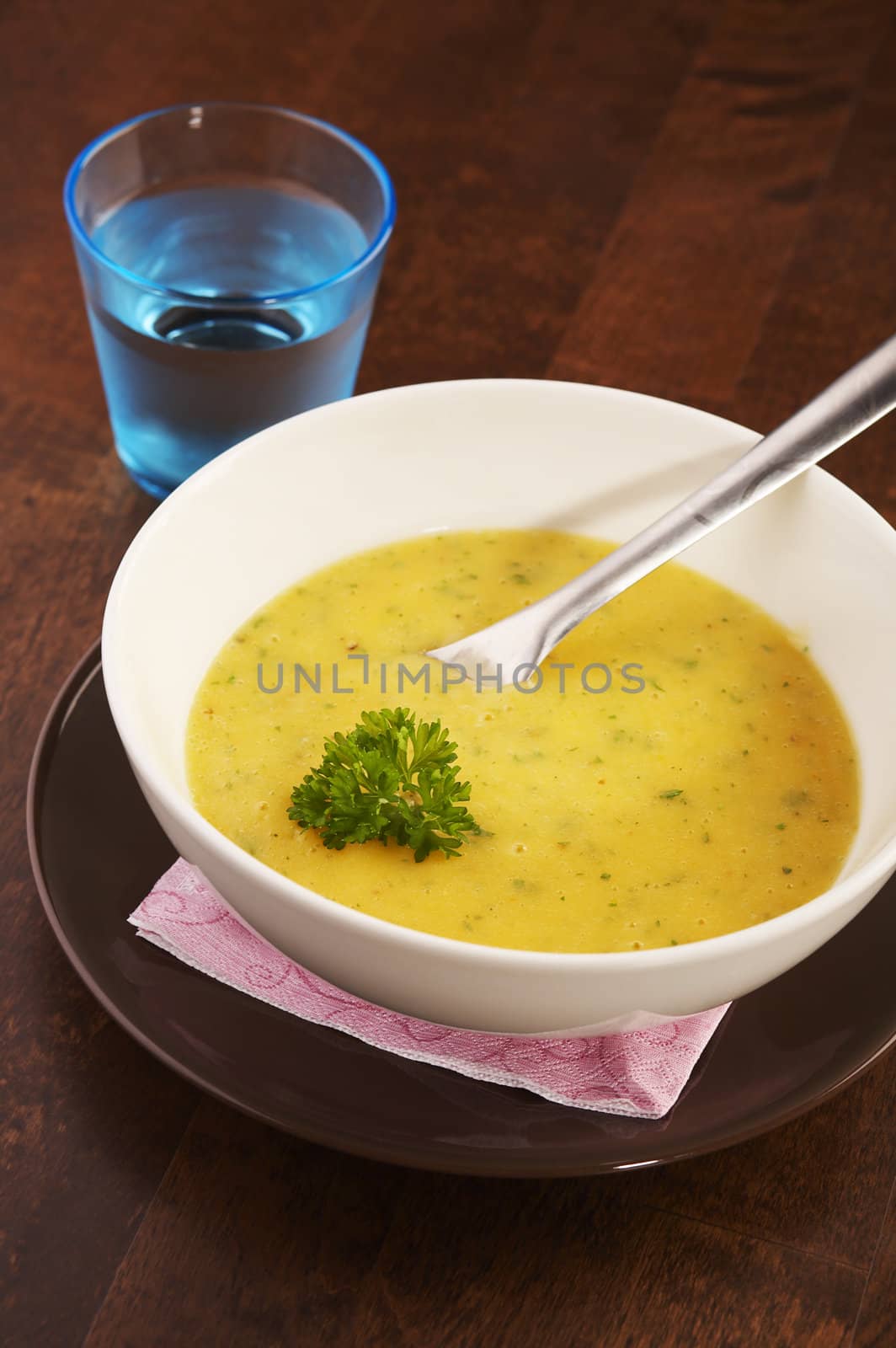 Yellow vegetable soup on a dark wooden table