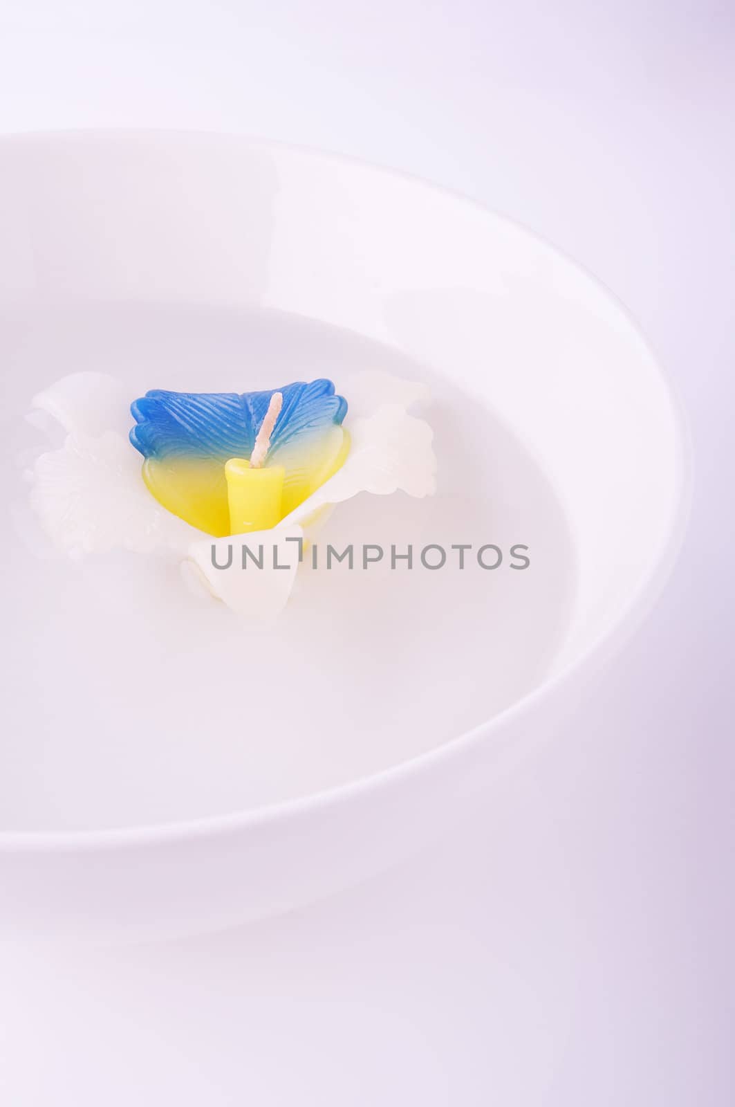 Floating candle in the vase on purple background