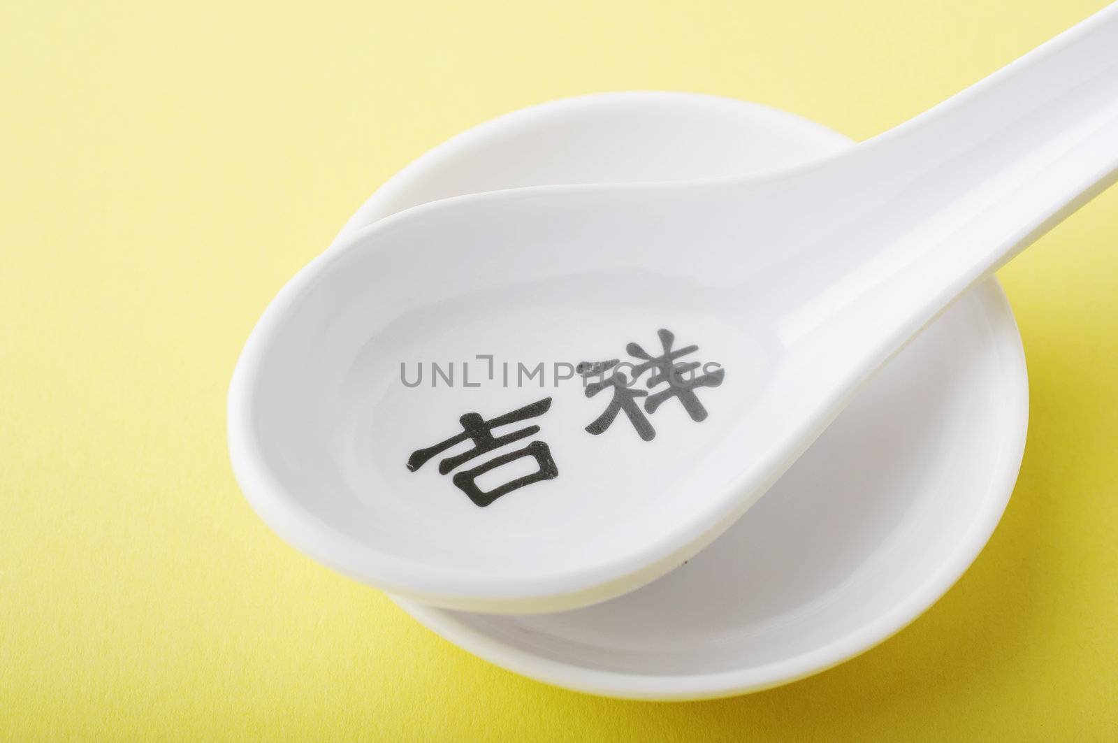 Asian style plastic spoon over a yellow background