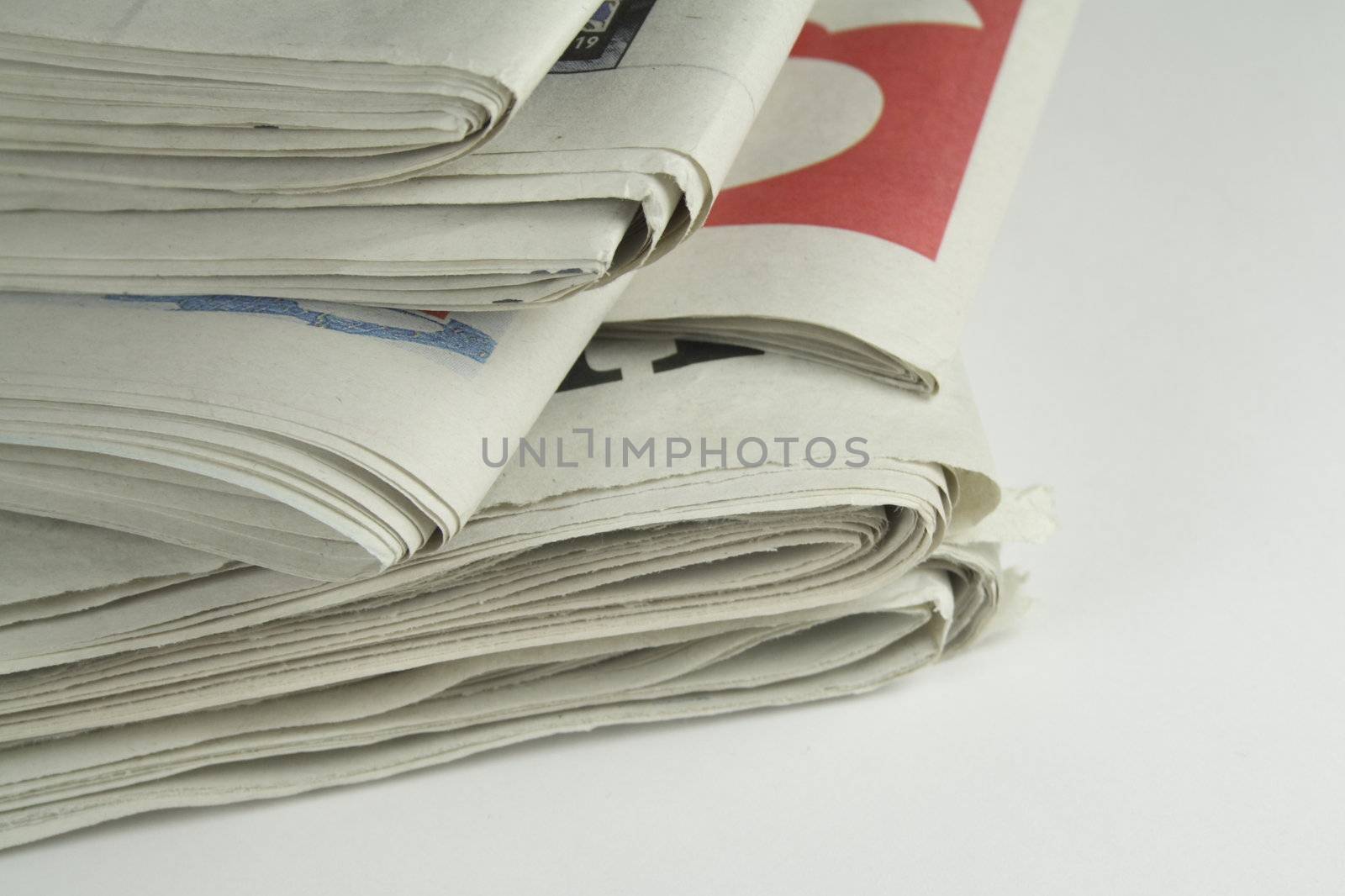 pile of daily newspapers by leafy