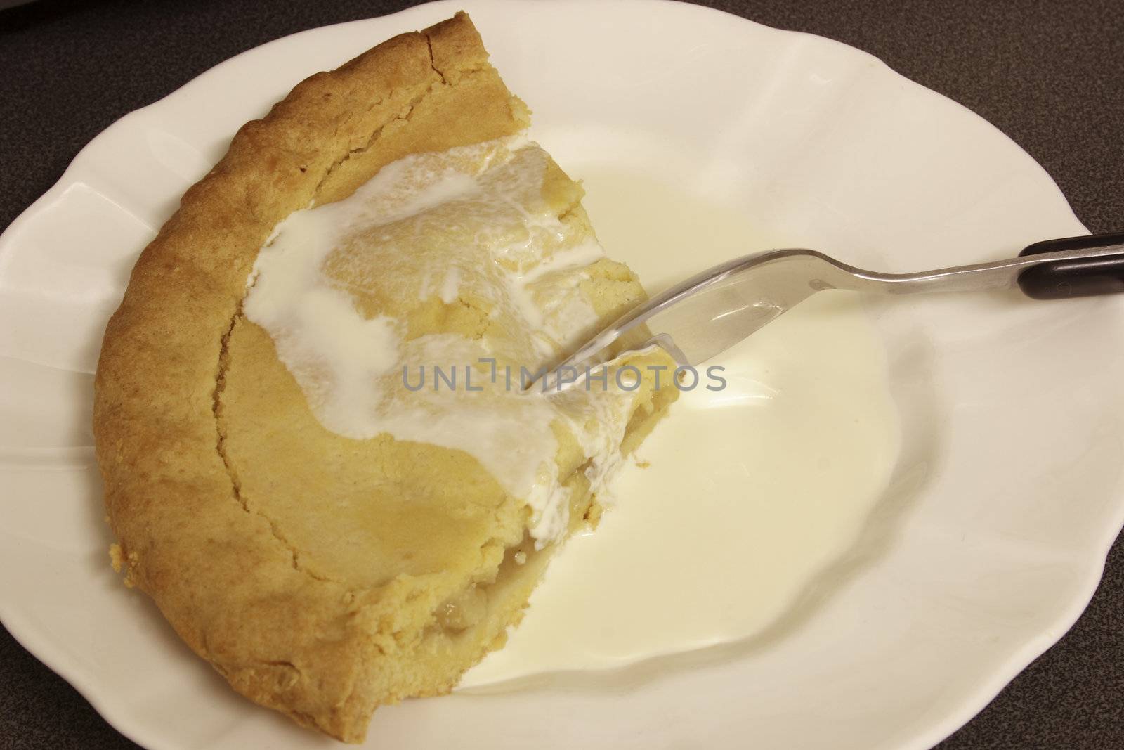 apple-pie and cream with a spoon being cut into the pastry a tasty dessert
