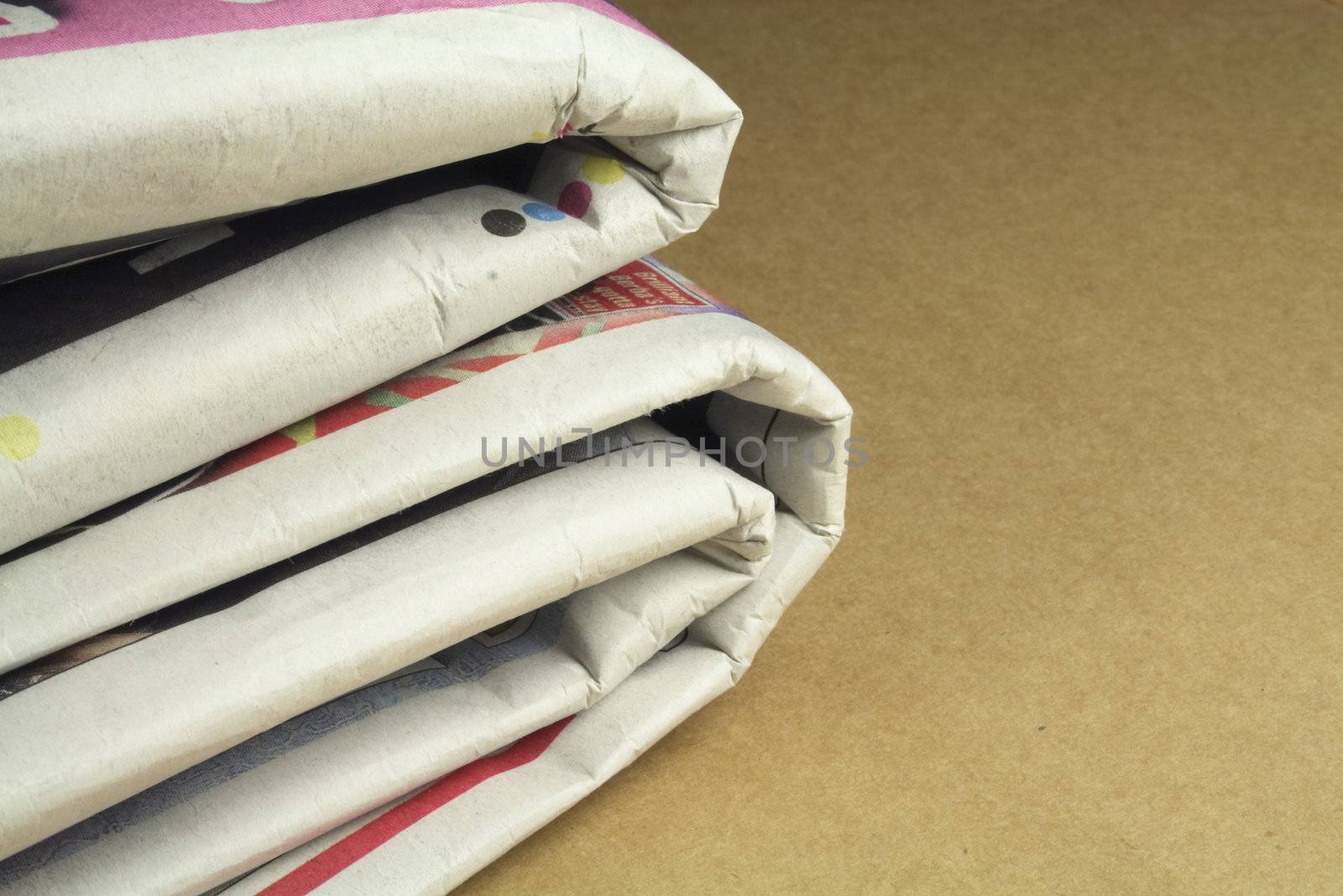 pile of daily newspapers by leafy