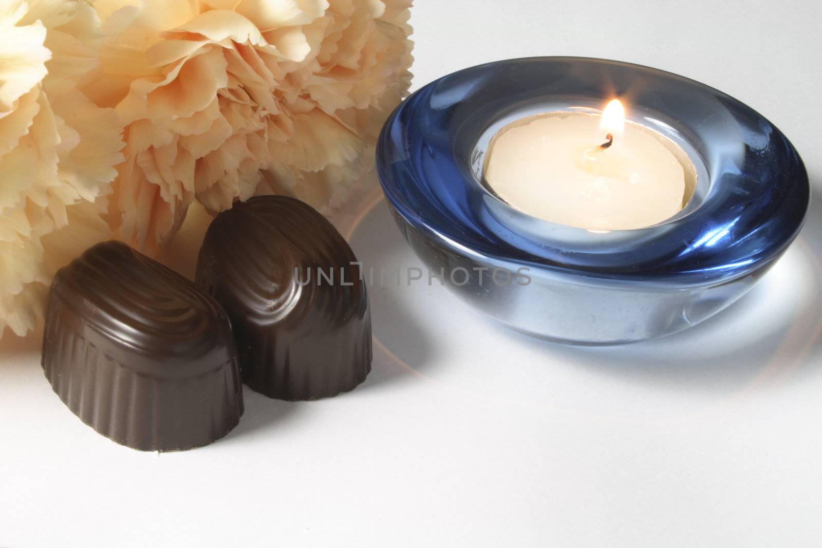chocolates and carnation with a candle by leafy