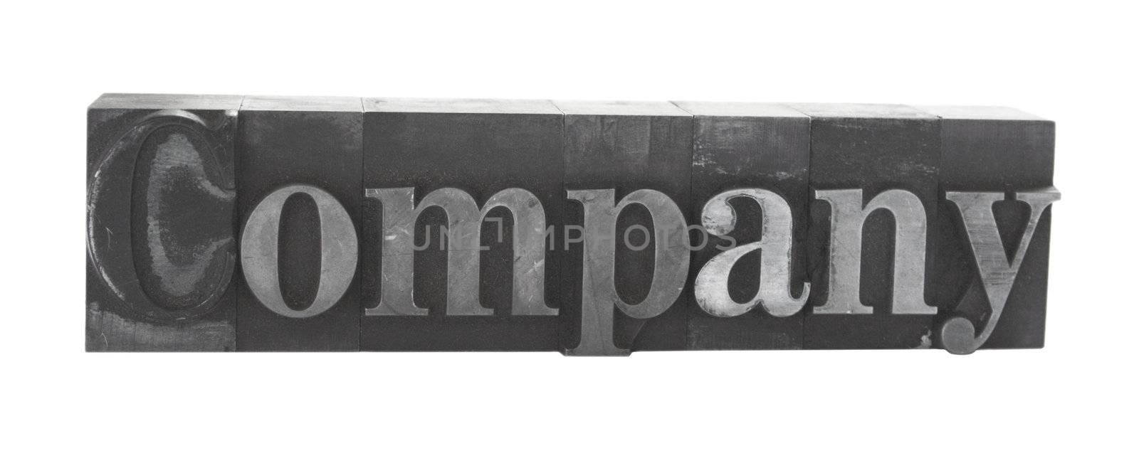 old, ink-stained metal letterpress type spells out the word 'company' isolated on white