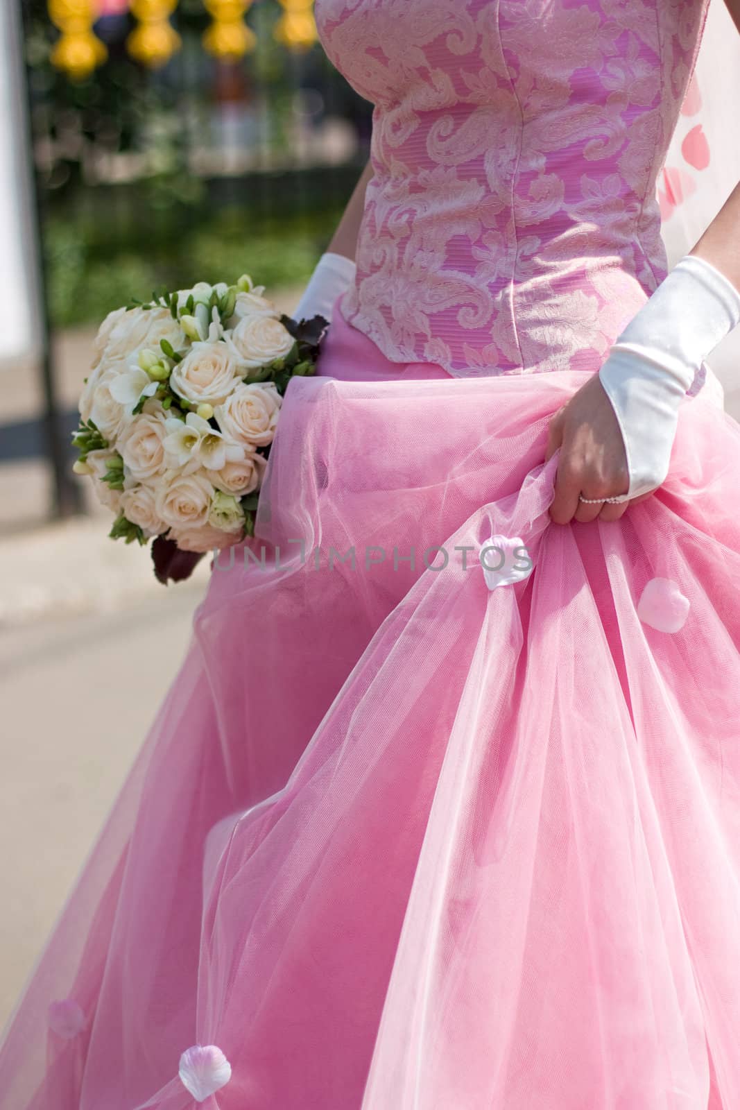 Bride with wedding bouquet at sunny day cropped