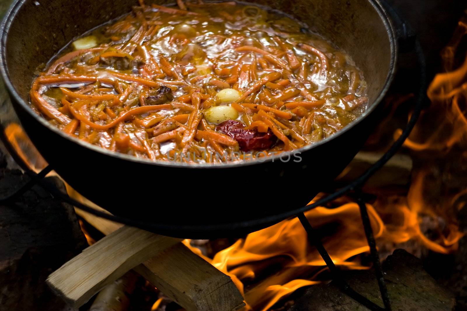 Cooking the traditional Uzbec pilaf in cauldron on fire