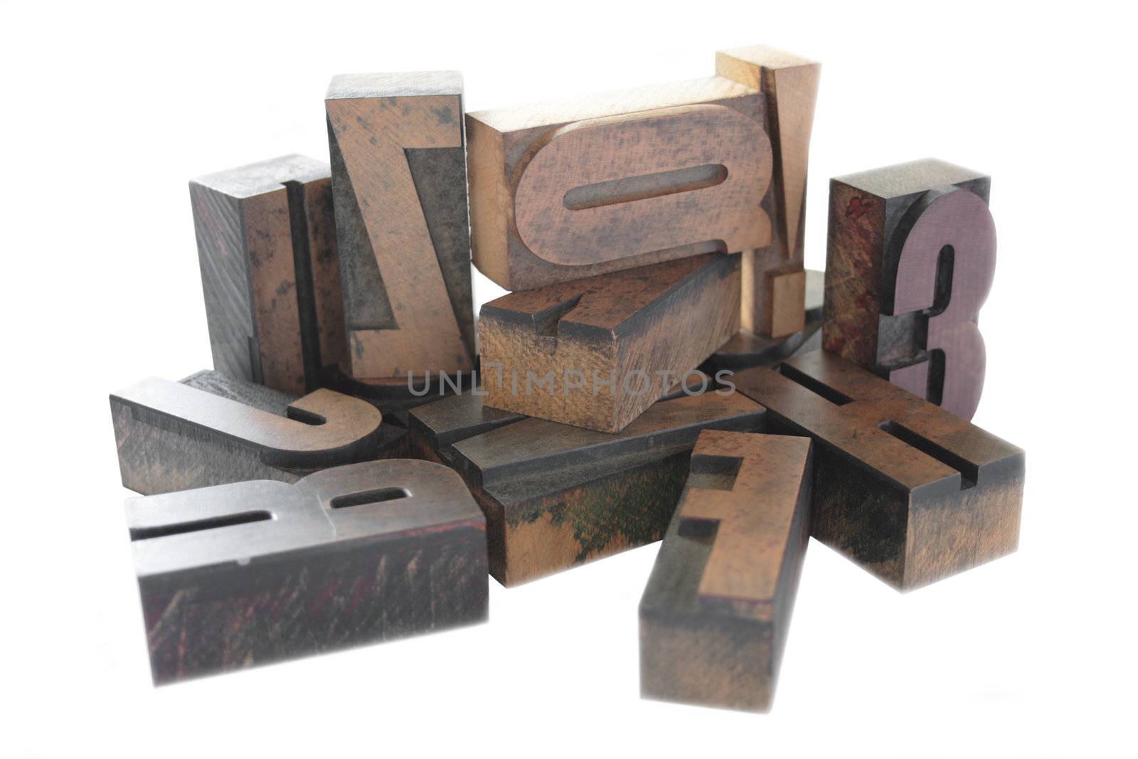 an arrangement of old, inkstained letterpress wood letters isolated on white
