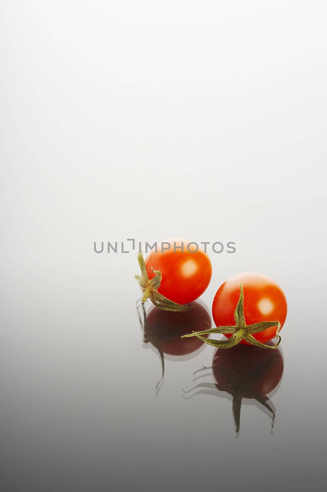 Miniature tomatoes on reflective surface