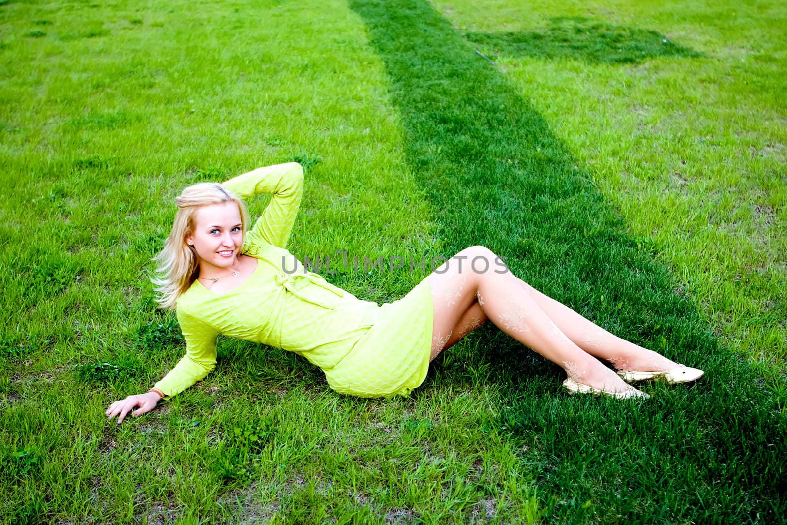 Portrait of the beautiful girl laying on a grass