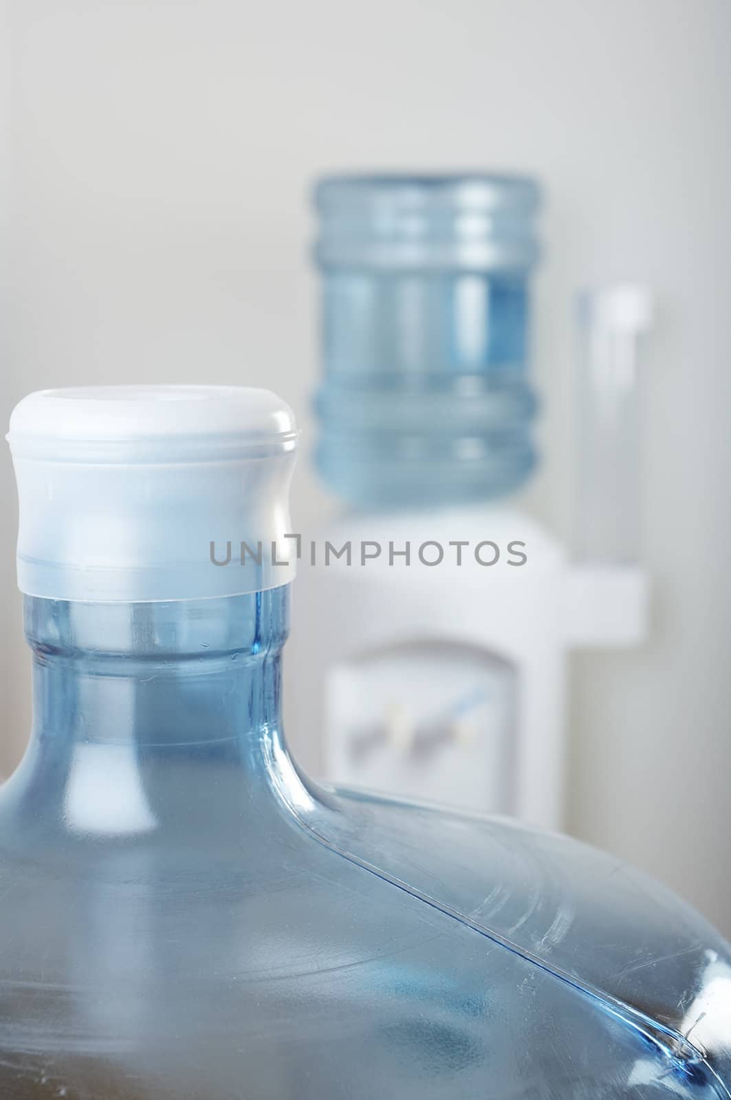 Empty water bottle front of office water cooler