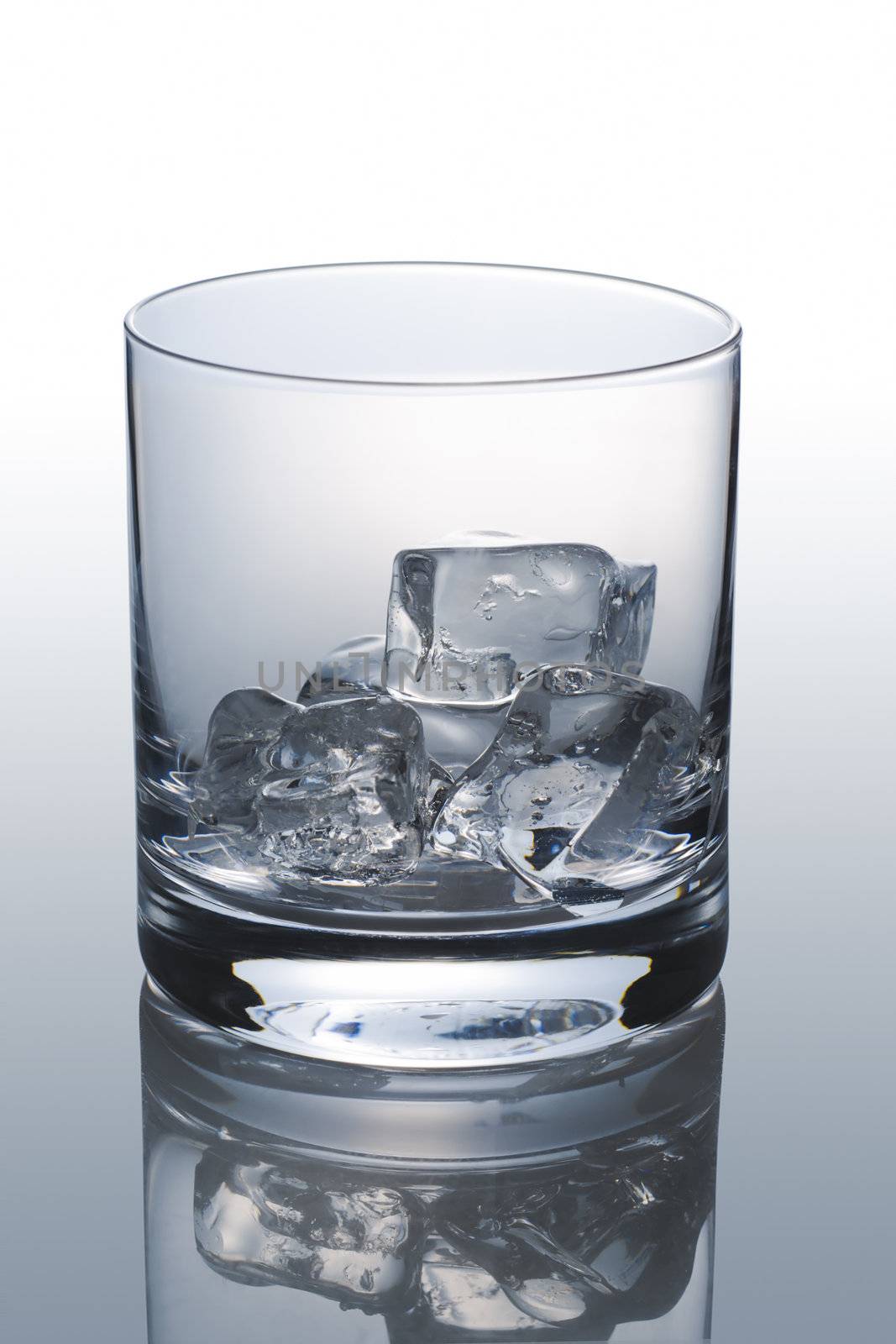 Front view of empty scotch glass on grey background