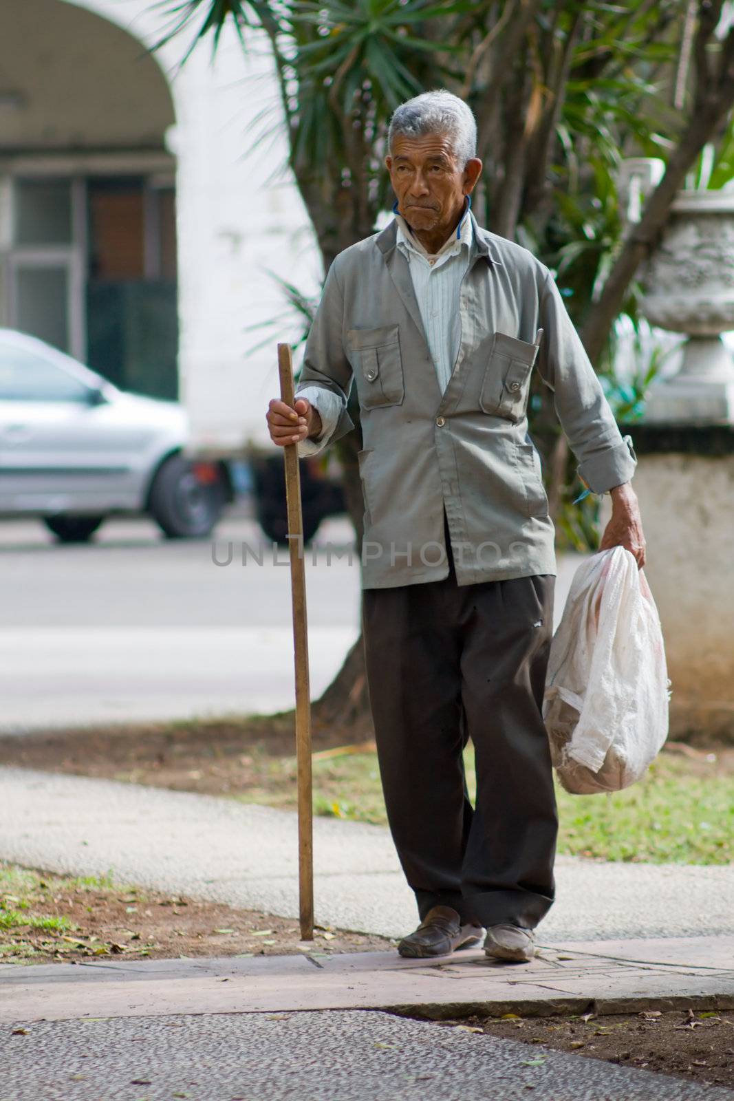 Old cuban tramp with a crutch. January 2008, Havana, Cuba.