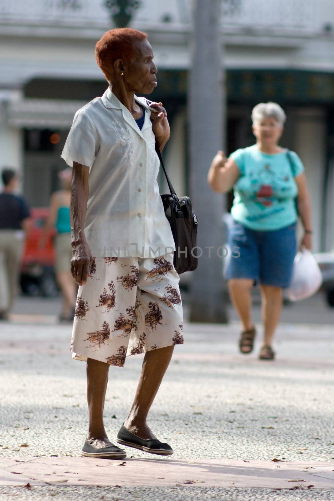 Old afro-american woman walking by Amidos