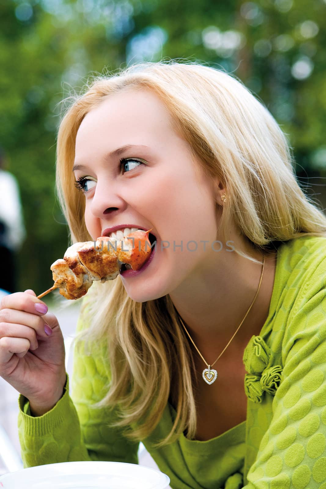 The girl eats a shish kebab by MIL