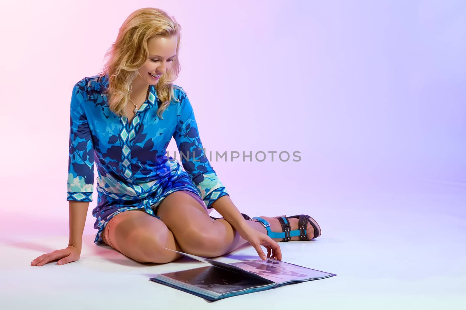 The beautiful girl looking through a fashion magazine