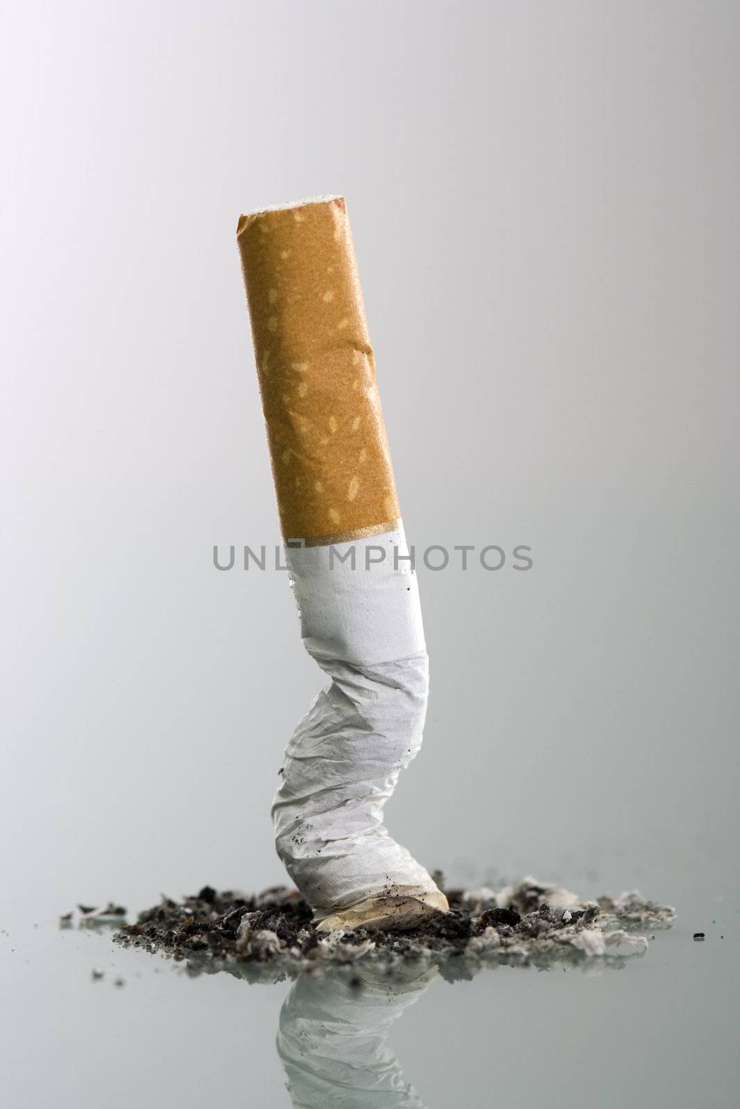 Cigarett butt end crushed into ashtray - grey background by mlopes