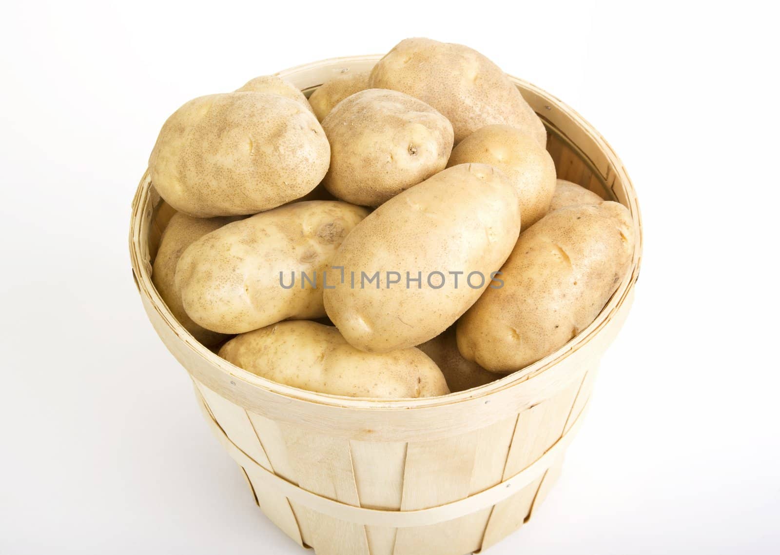 Potatoes in a woven basket on a white background