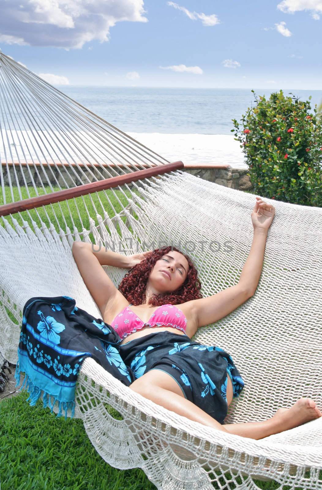 Beautiful young woman laying in large hammock