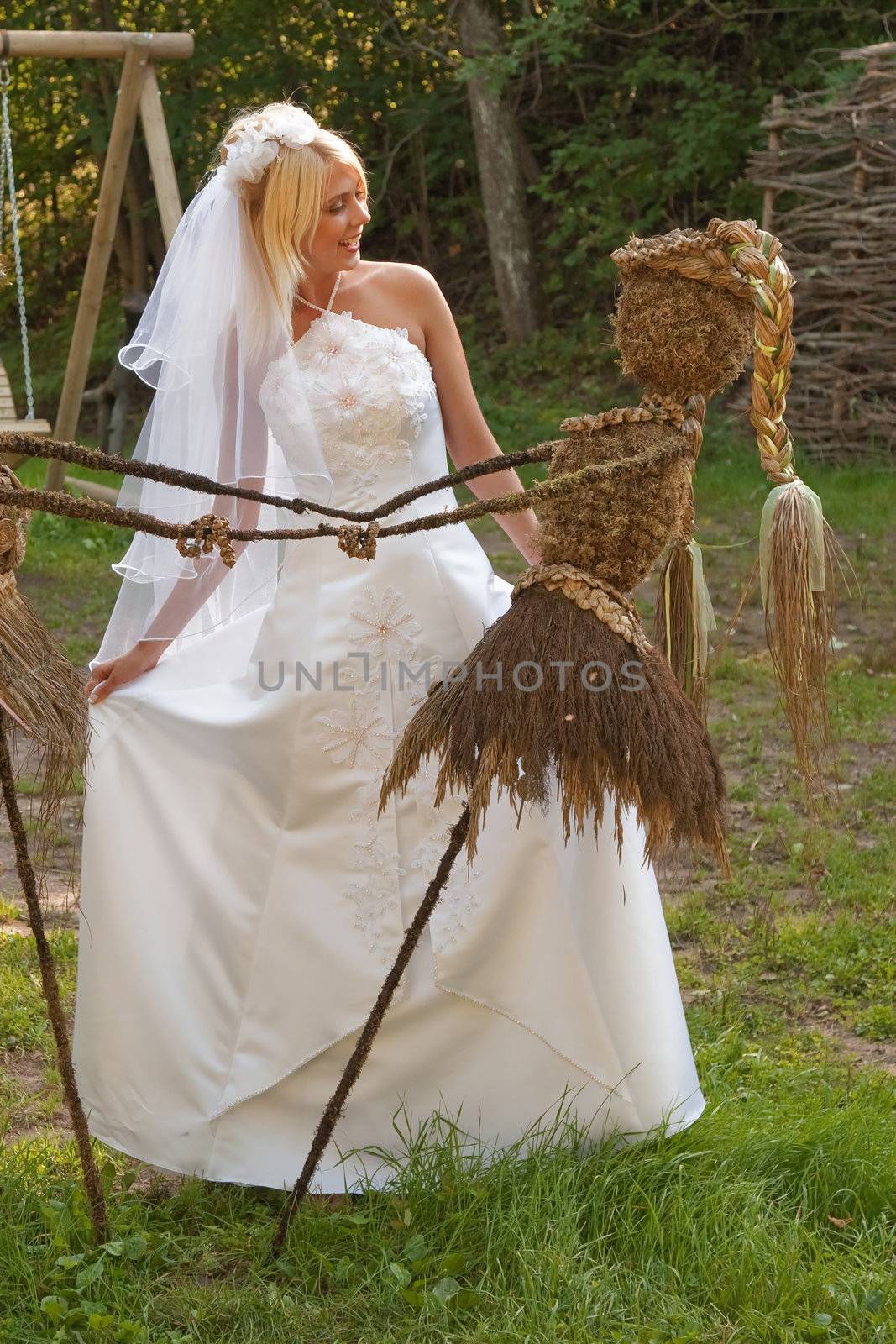 Beautiful blonde bride in white dress posing outdoor