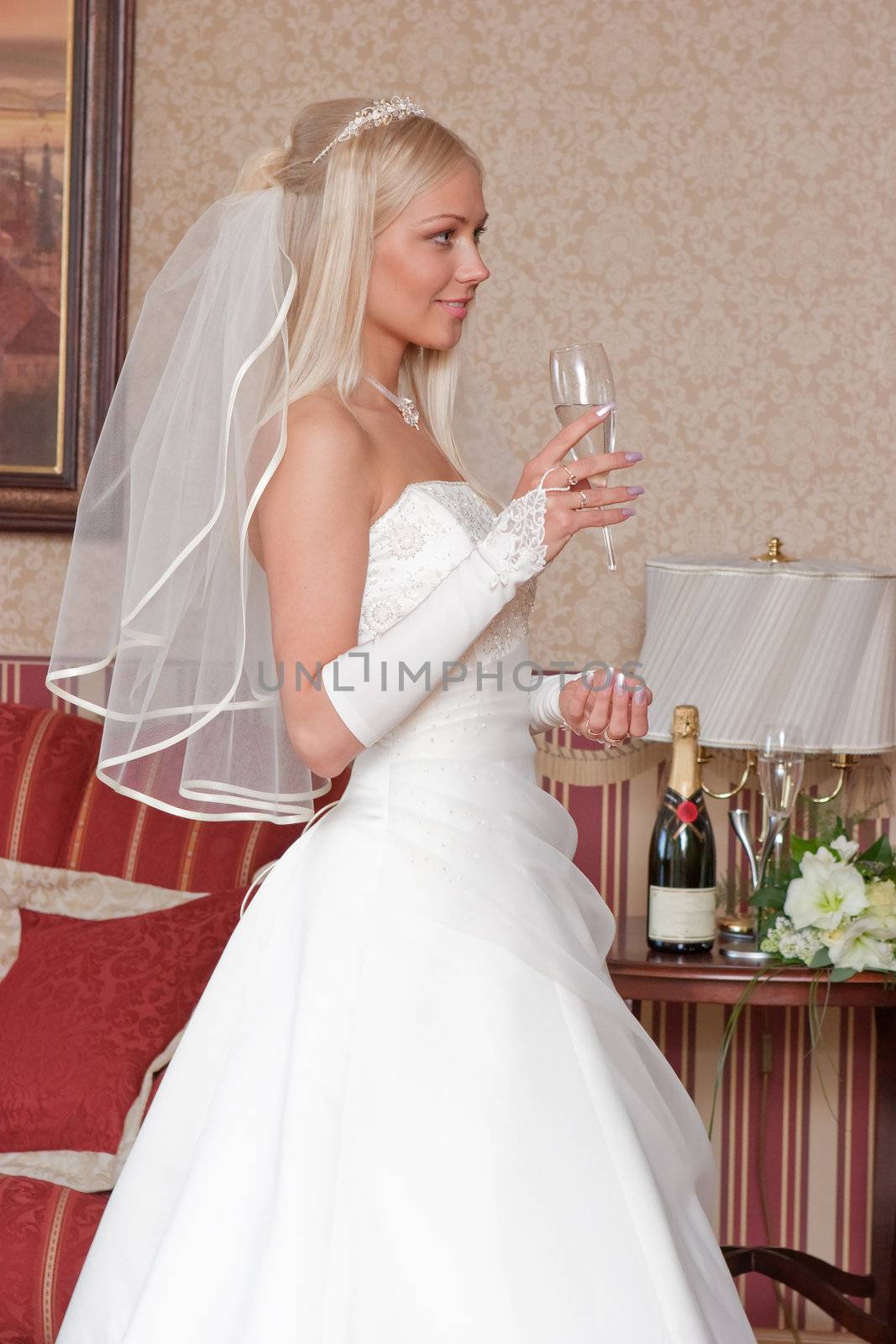 Beautiful blonde bride with glass of champagne