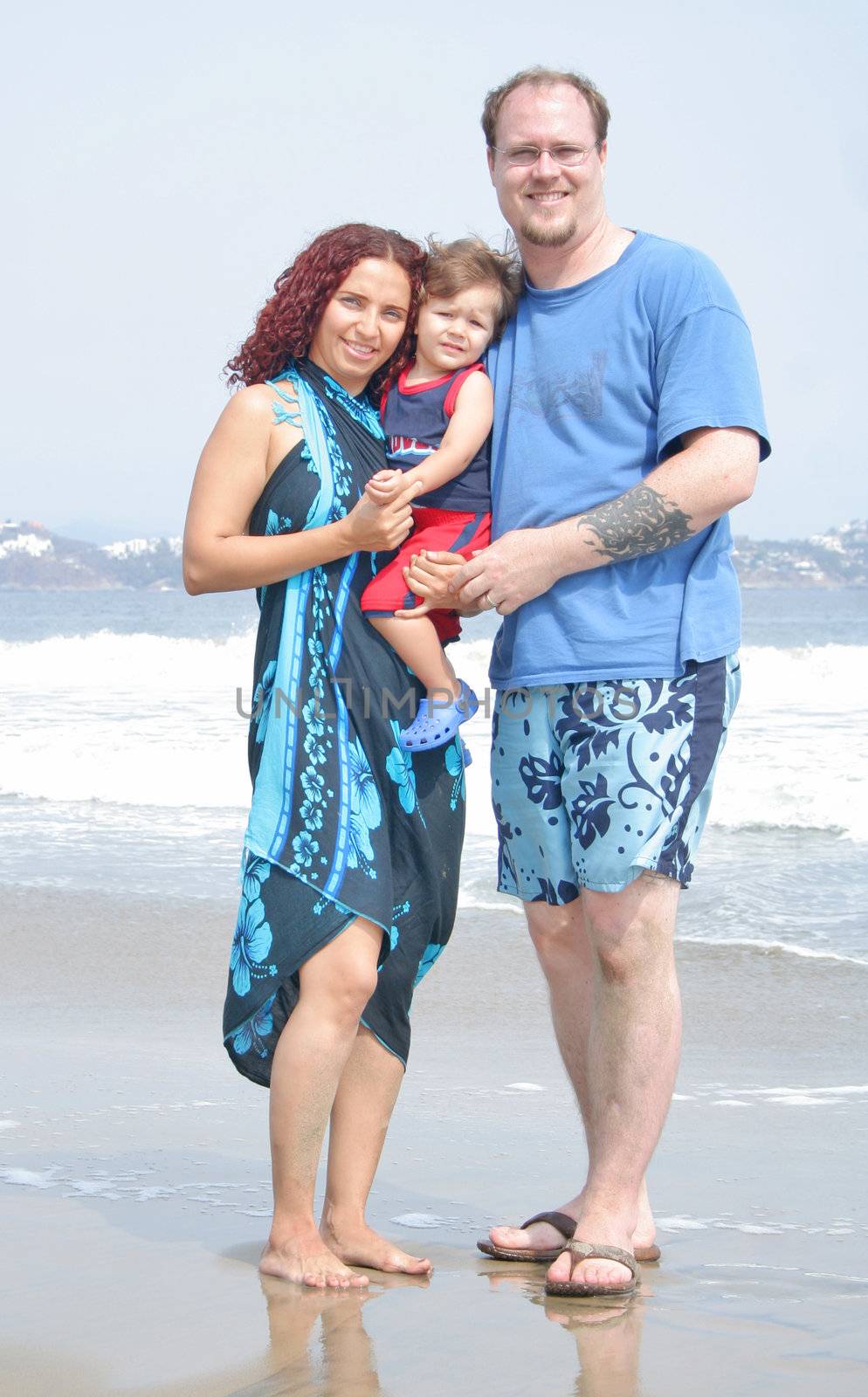 Young happy family together on the beach