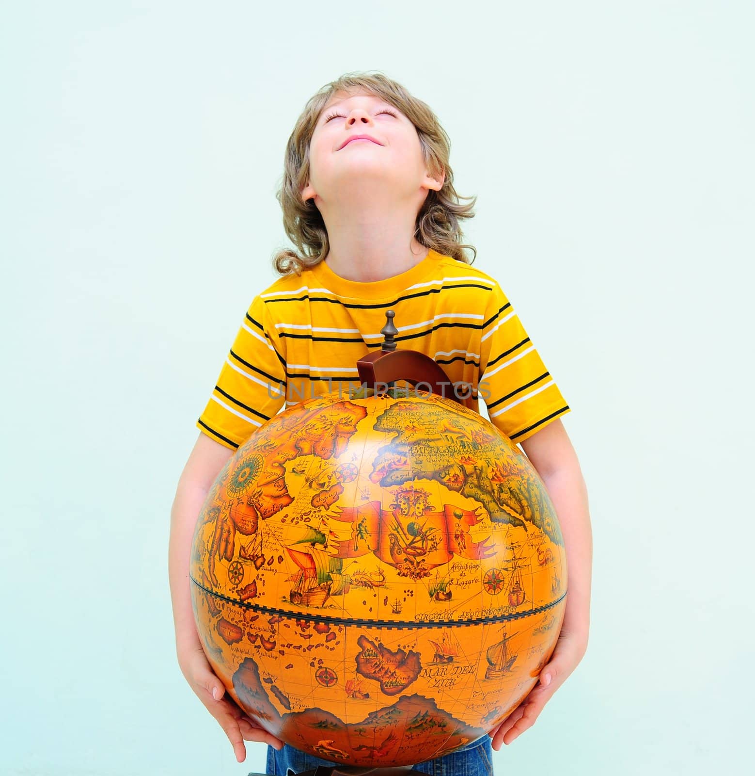 Teen Hugging Old Fashioned Globe Against Light Green Background