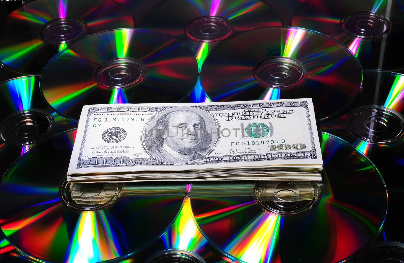 One Hundred Dollar Bills On Some Colorful Compact Discs