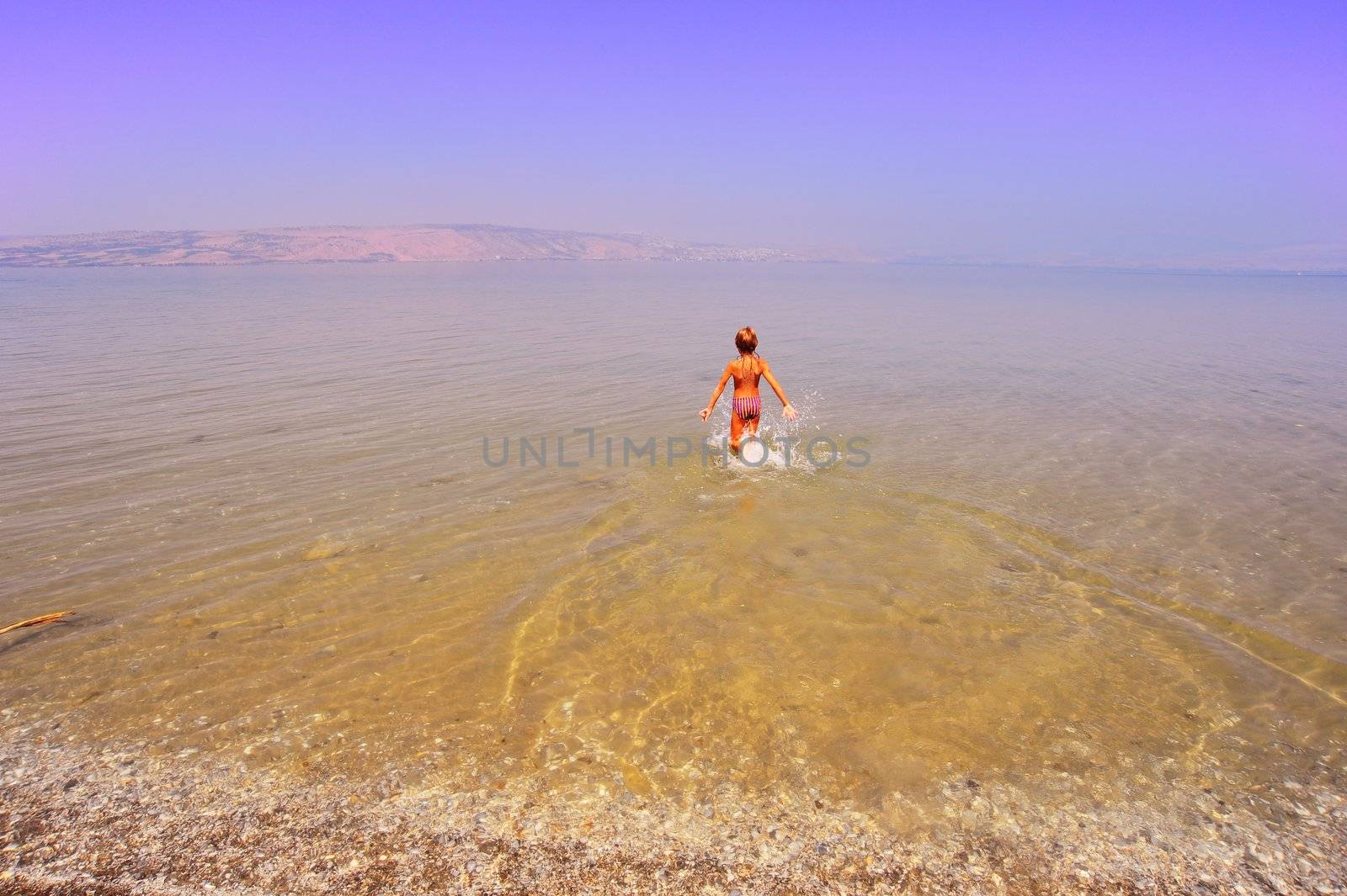 Happy Boy Running In Water Of Galilee Sea, Kinneret, Early In The Morning