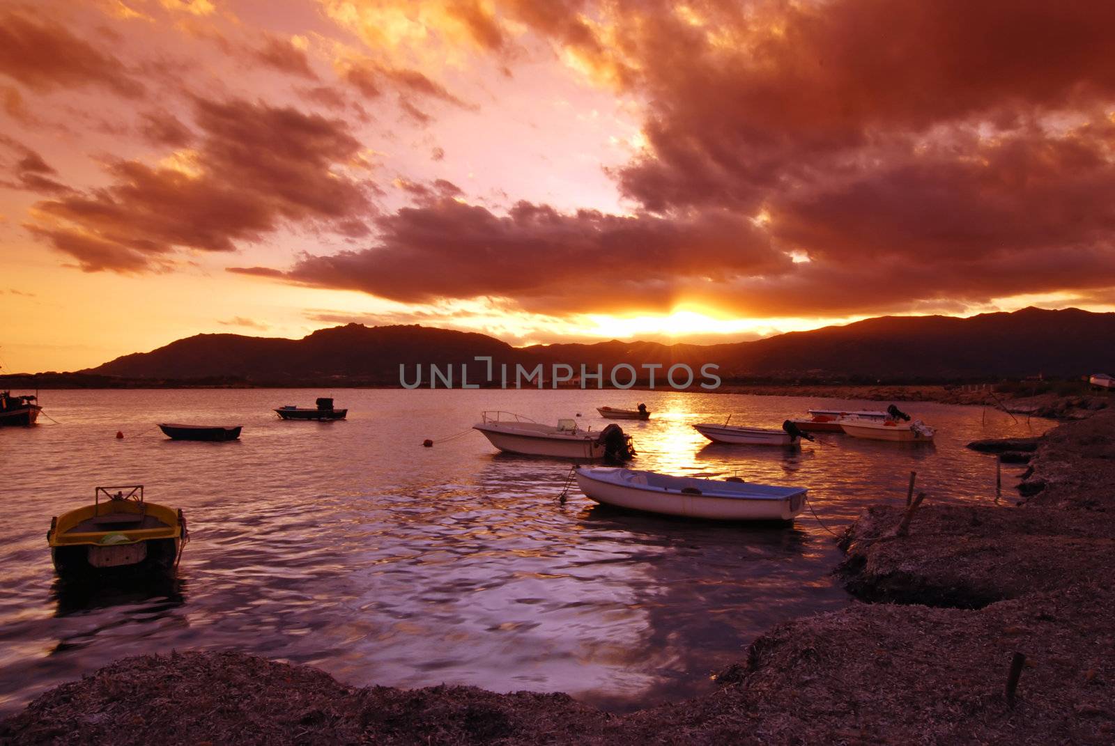 Beautiful sunset over harbor with dramatic sky on Sardinia