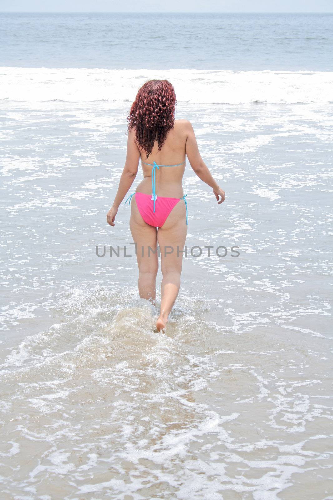 Woman playing in the ocean with waves rolling in