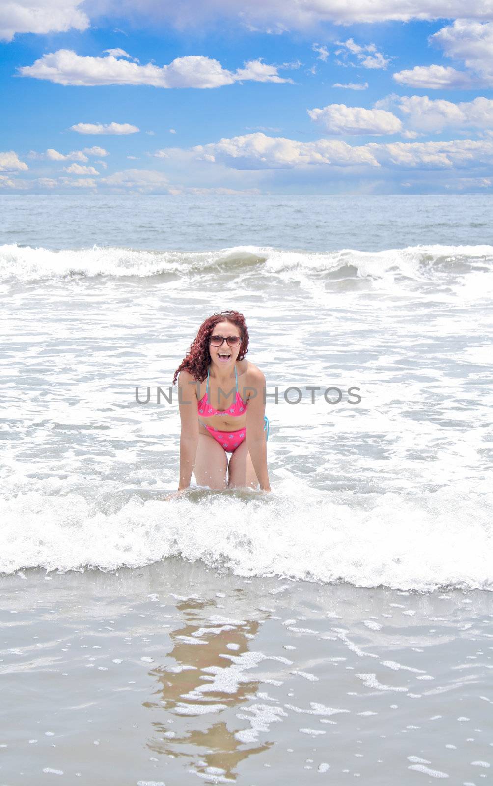 Pretty young woman playing in the waves