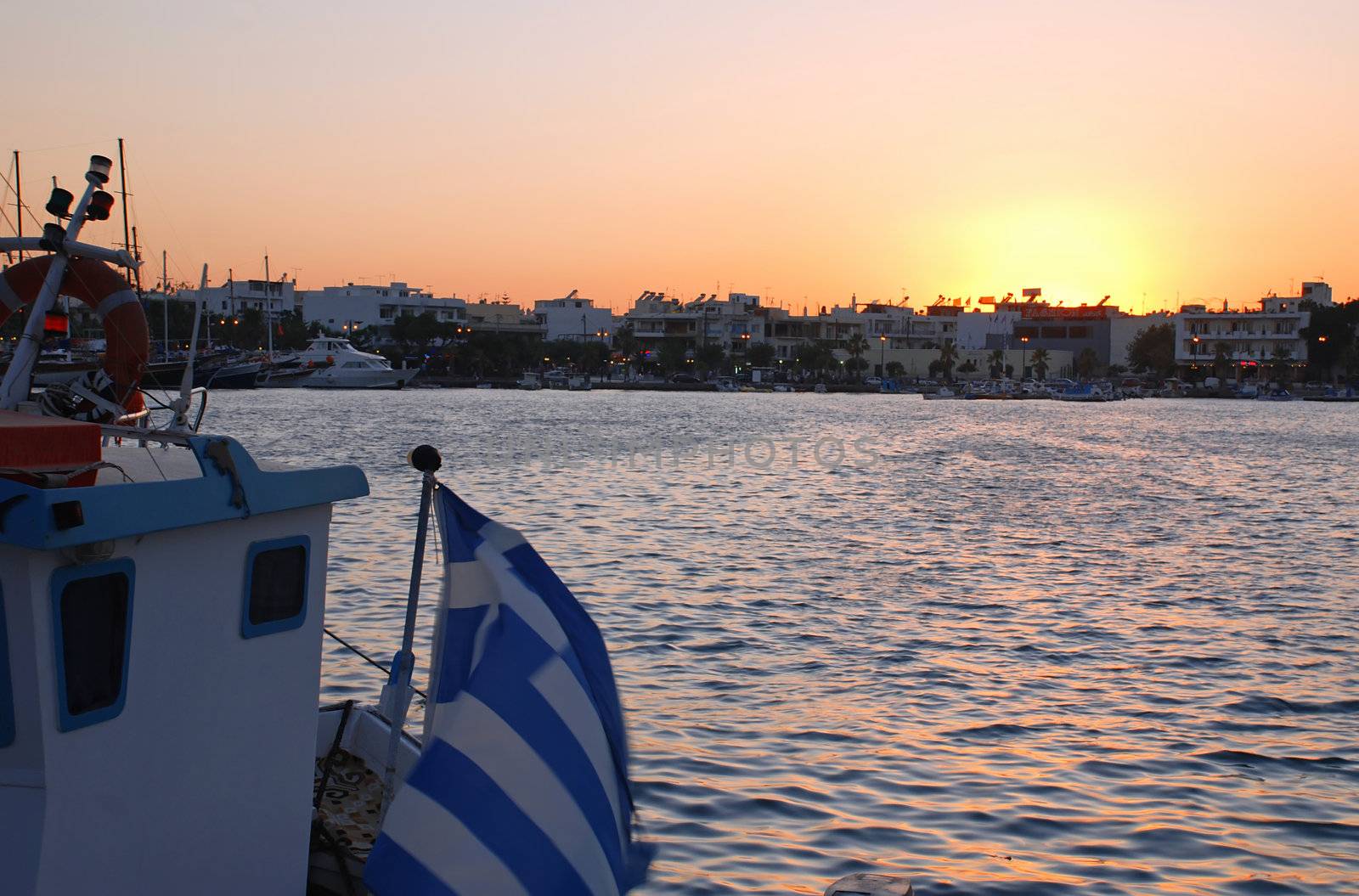 Ship with a Greek flag in a Harbour of Kos during the sunset