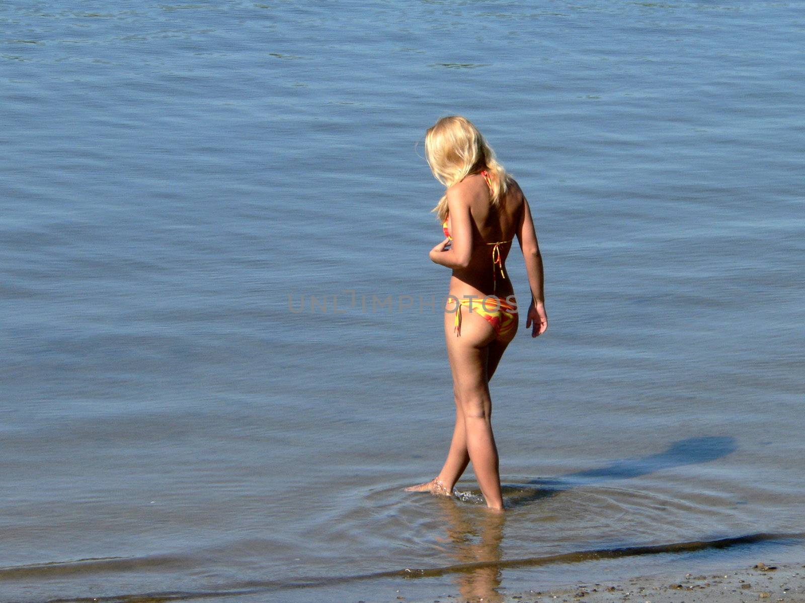 Young girl enter into the rivers water 2