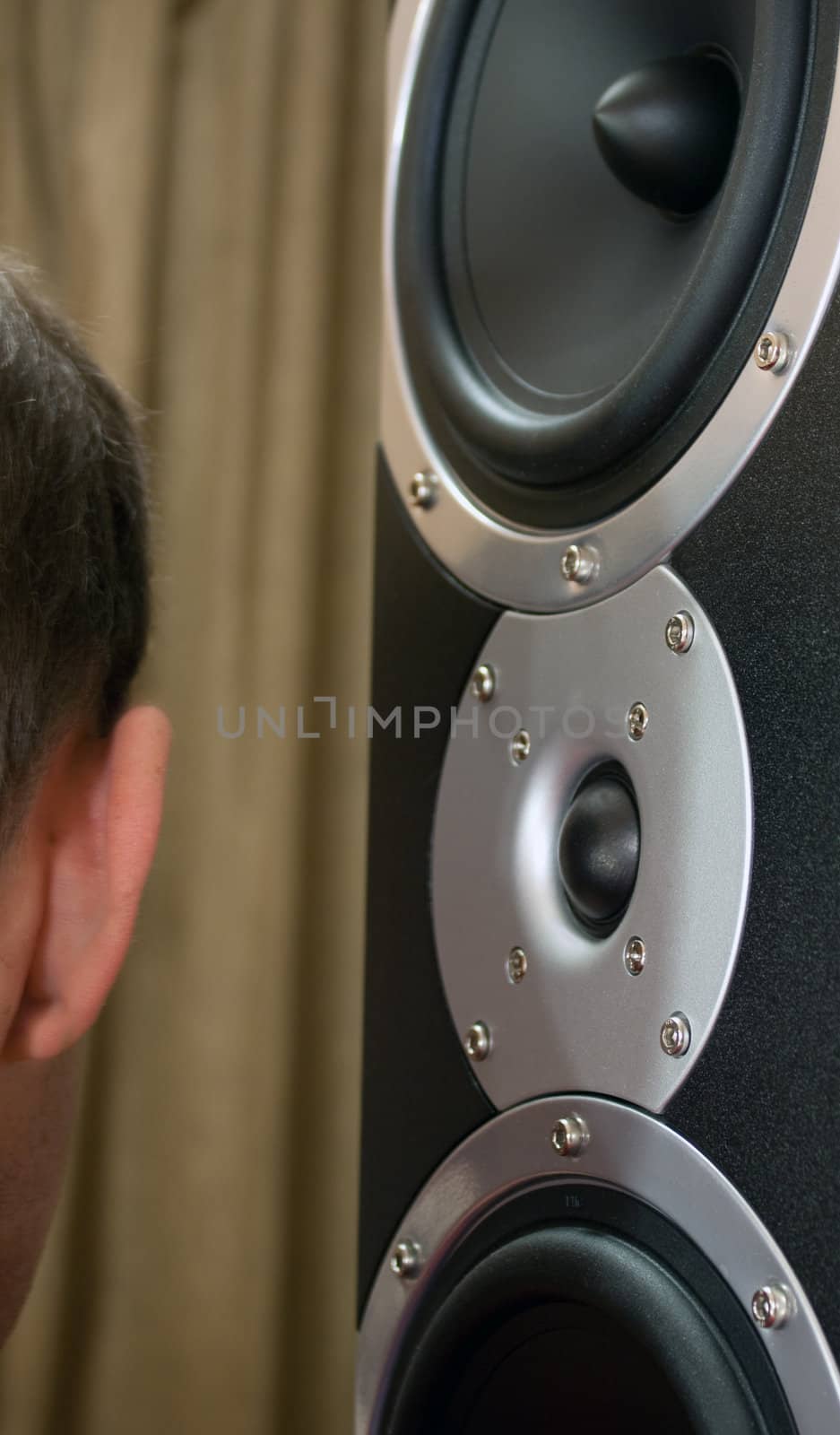 Audiophile speakers. Man listens to music pressed his ear