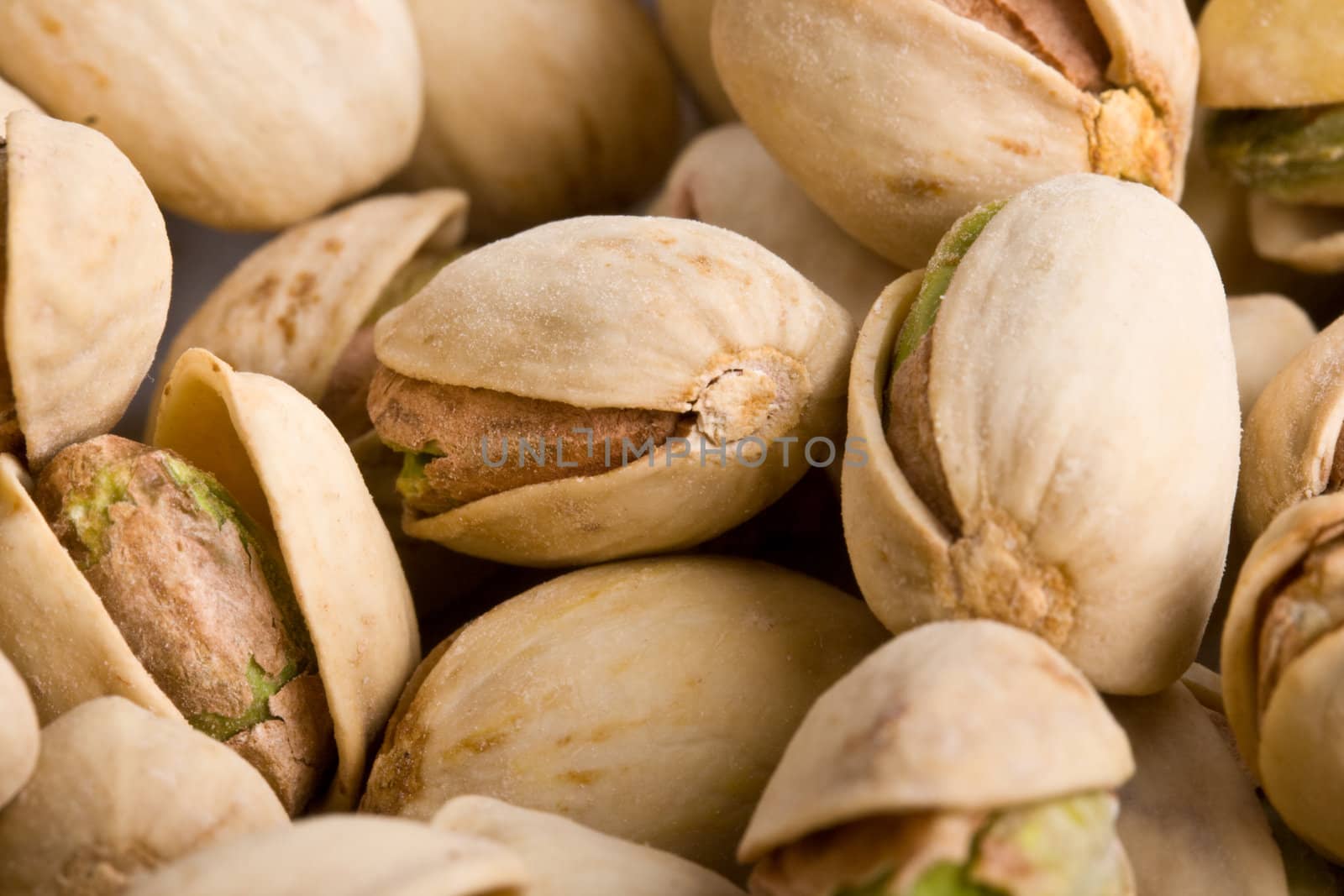 Pile of pistachio nuts close up - focus on one