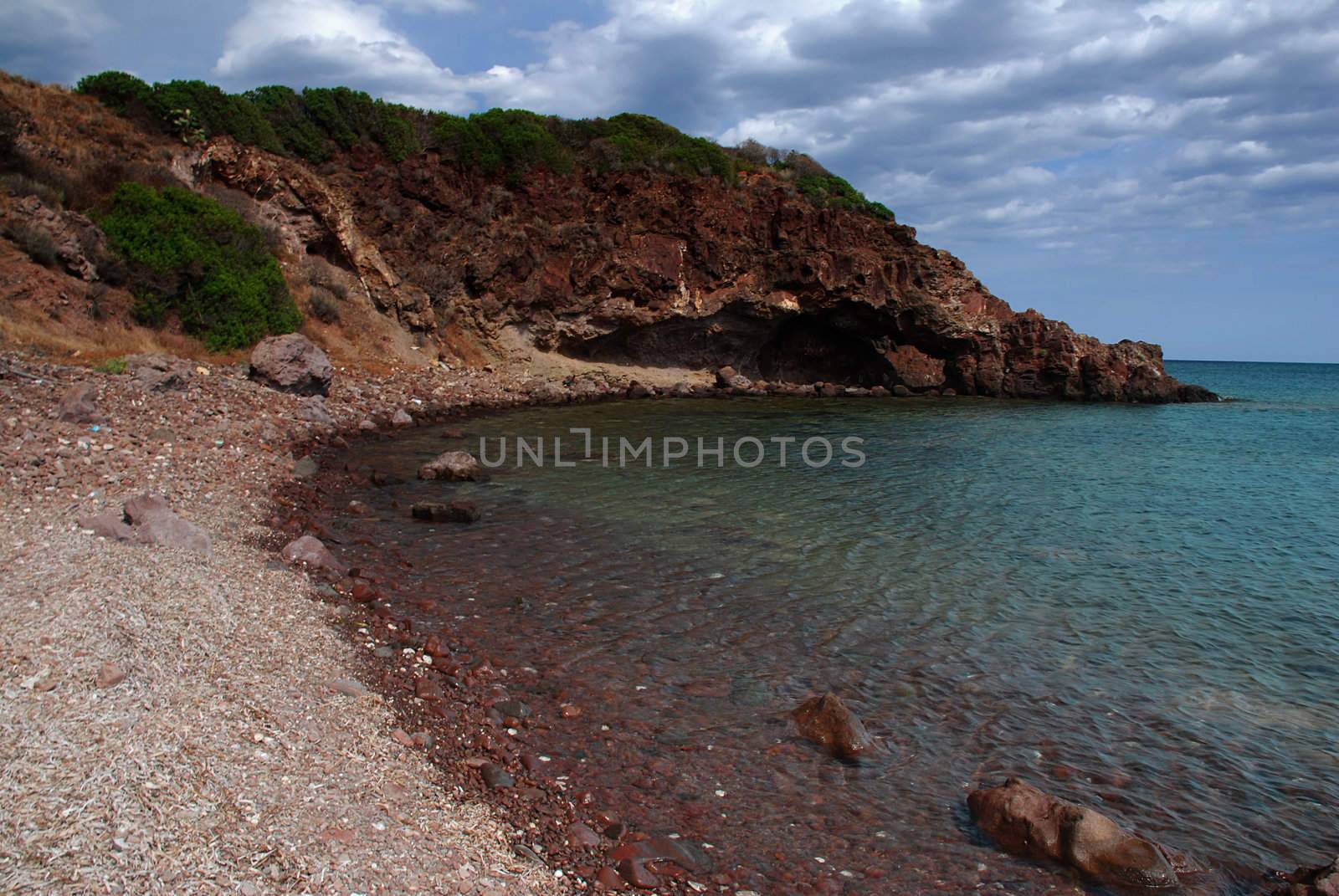 Beach surrounded by rock with a cave in the end