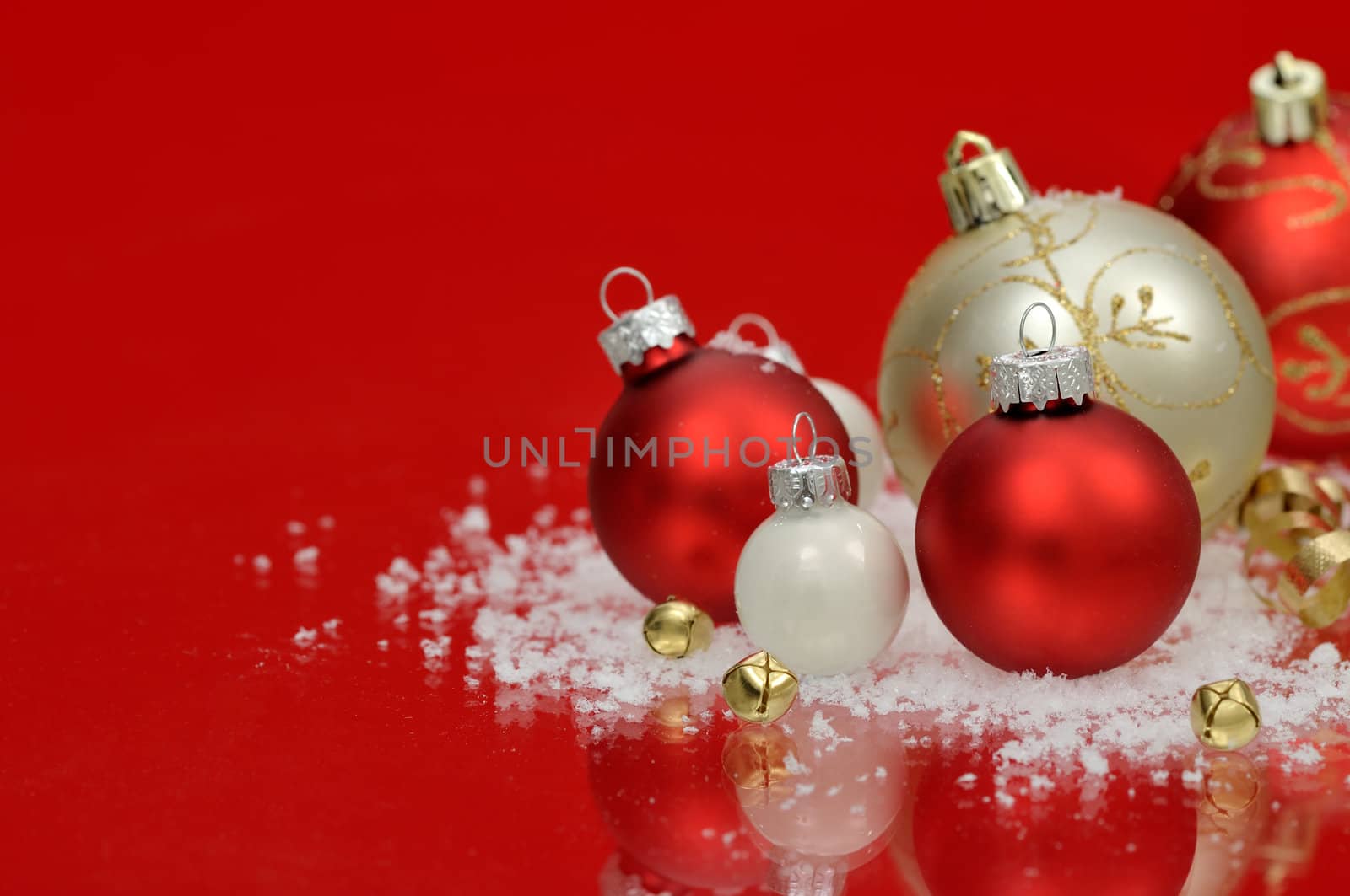 Red and white baubles with snow and jingle bells on red background