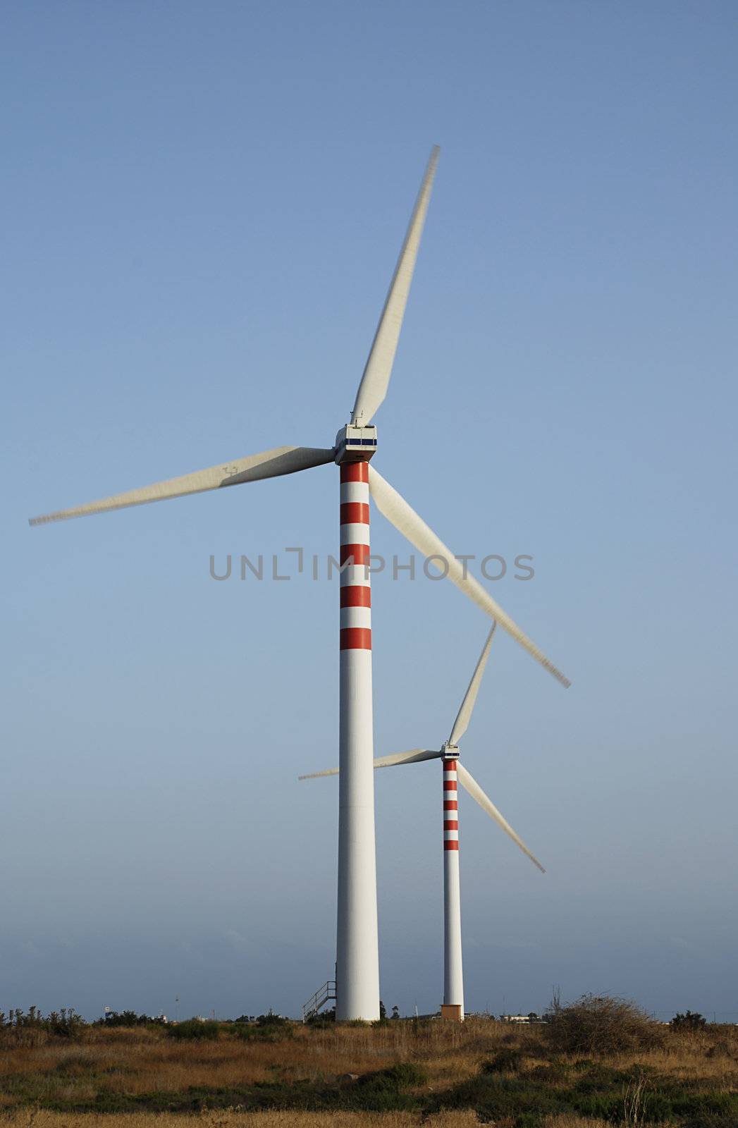 Two wind turbines generating energy - with slight motion blur