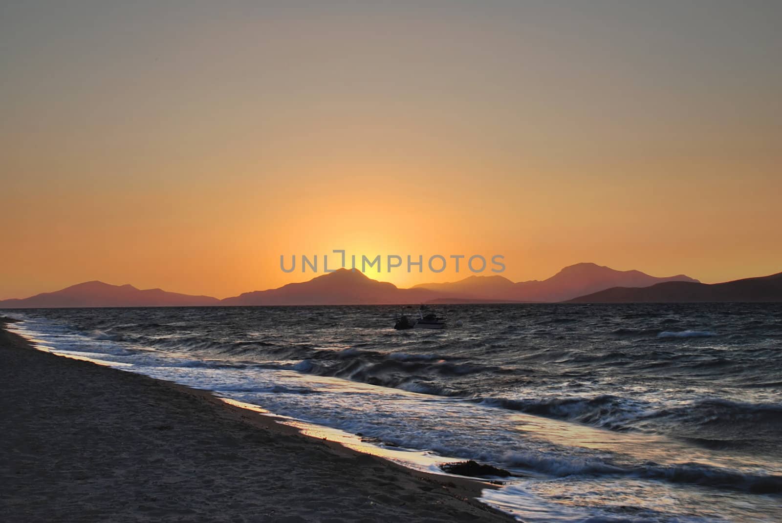 Sun is setting behind the mountains and sea