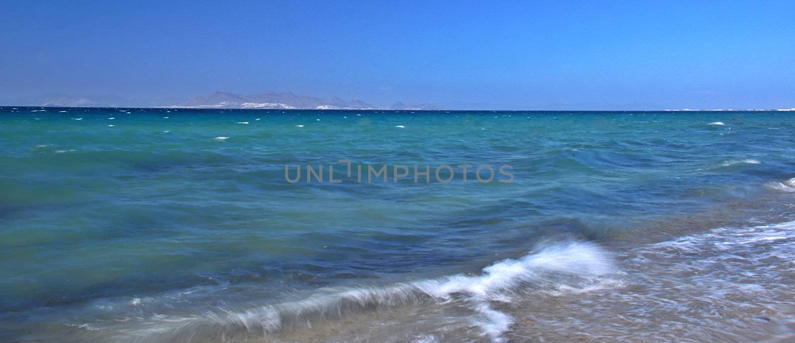 Beautiful blue sea with a waves hitting the beach