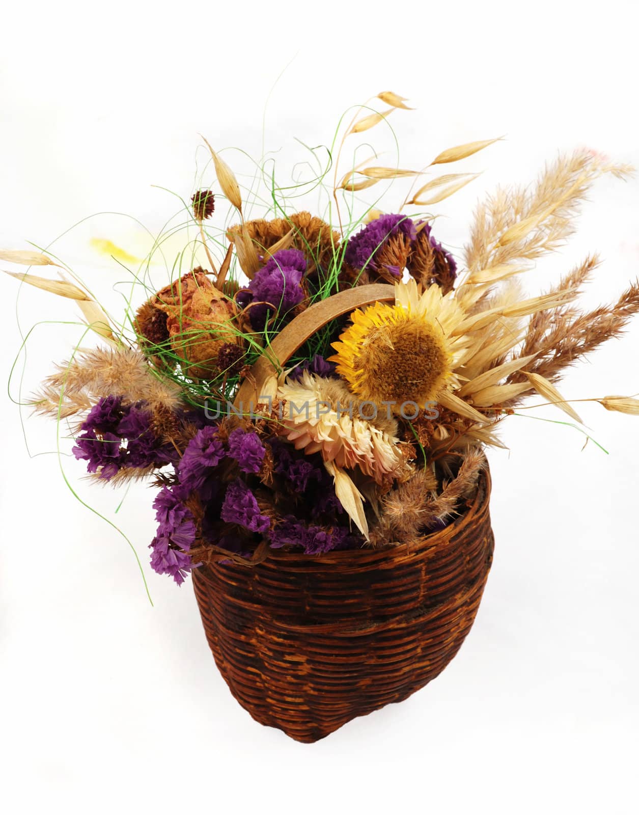 Dry flowers in the small basket arranging on the white background